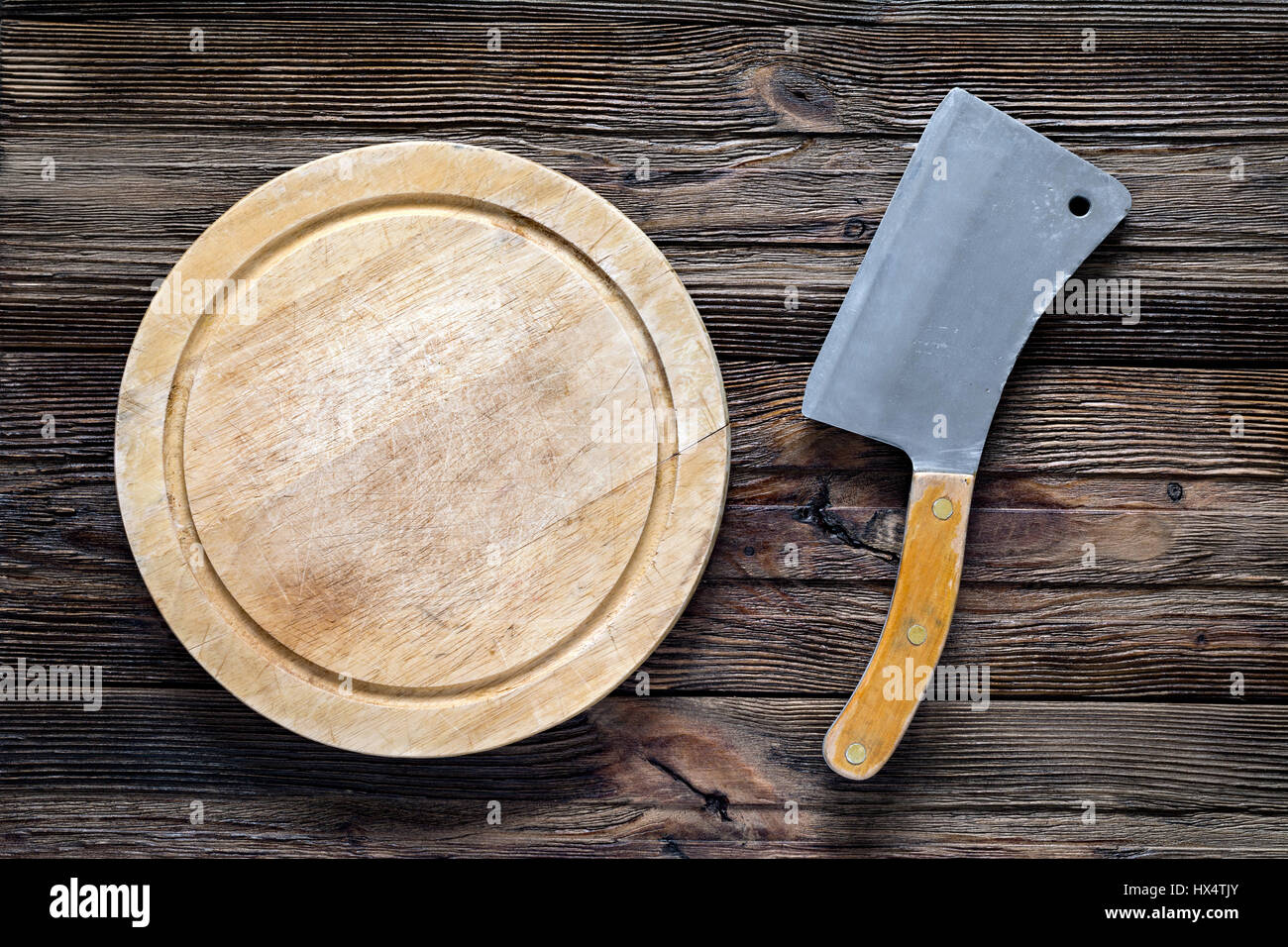 Vecchia mannaia di carne o coltello da prosciutto e round tagliere di legno. Vista da sopra con lo spazio di copia Foto Stock