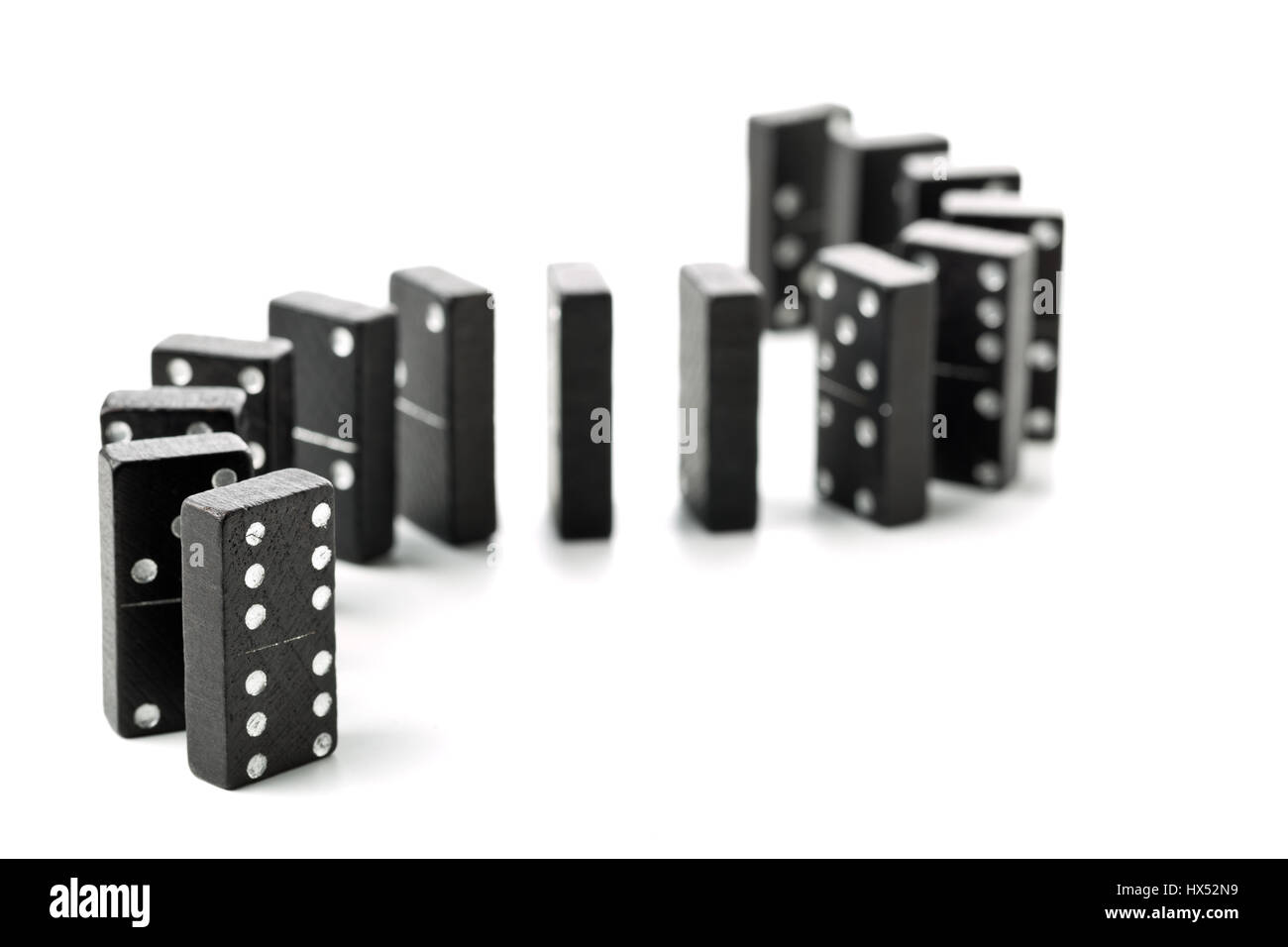 Gioco di Domino pietre in una curva ad S di forma permanente di riga su sfondo bianco Foto Stock