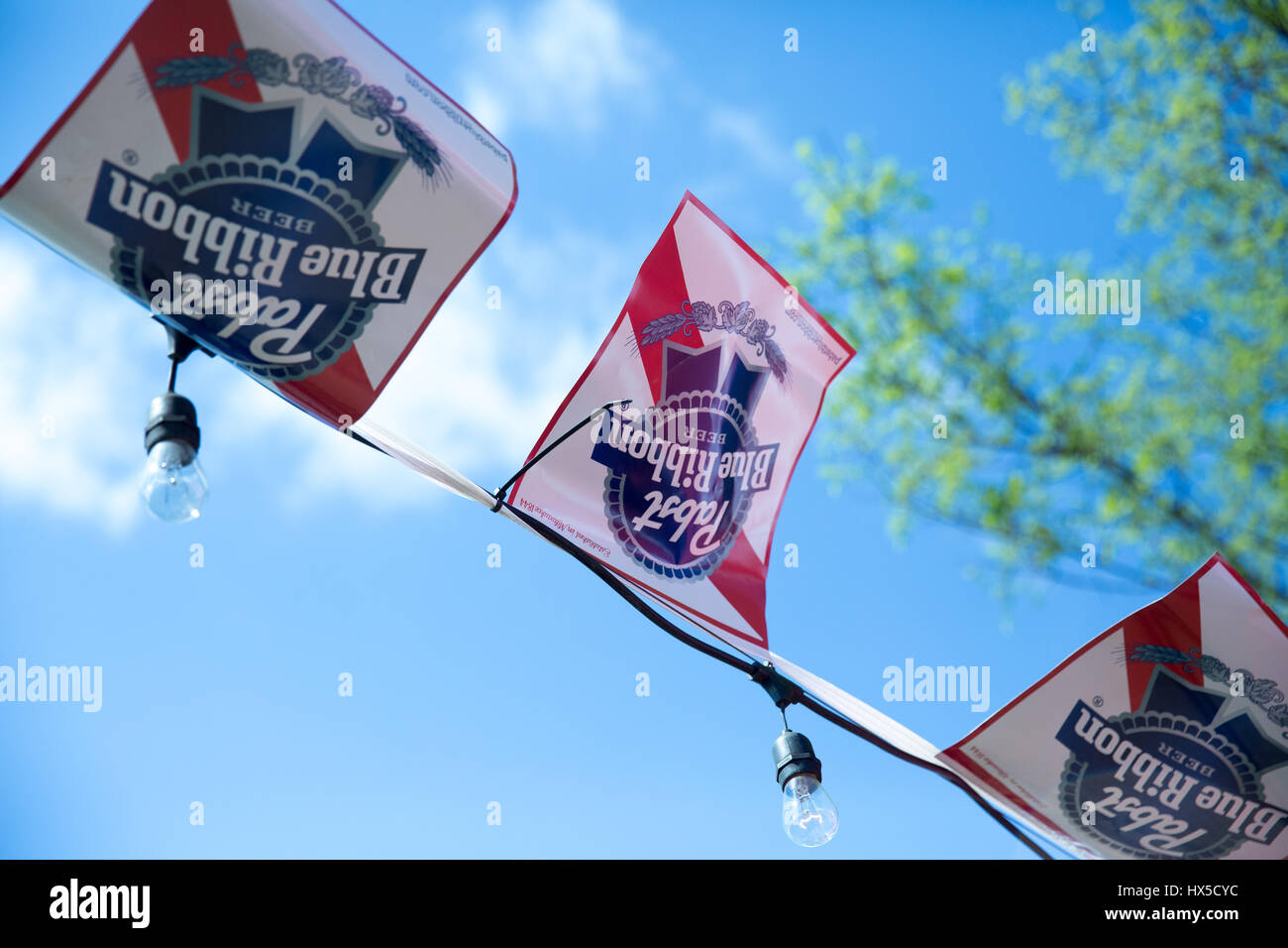 Dettaglio del Pabst Blue Ribbon branded bunting contro il cielo blu e albero in background. Foto Stock