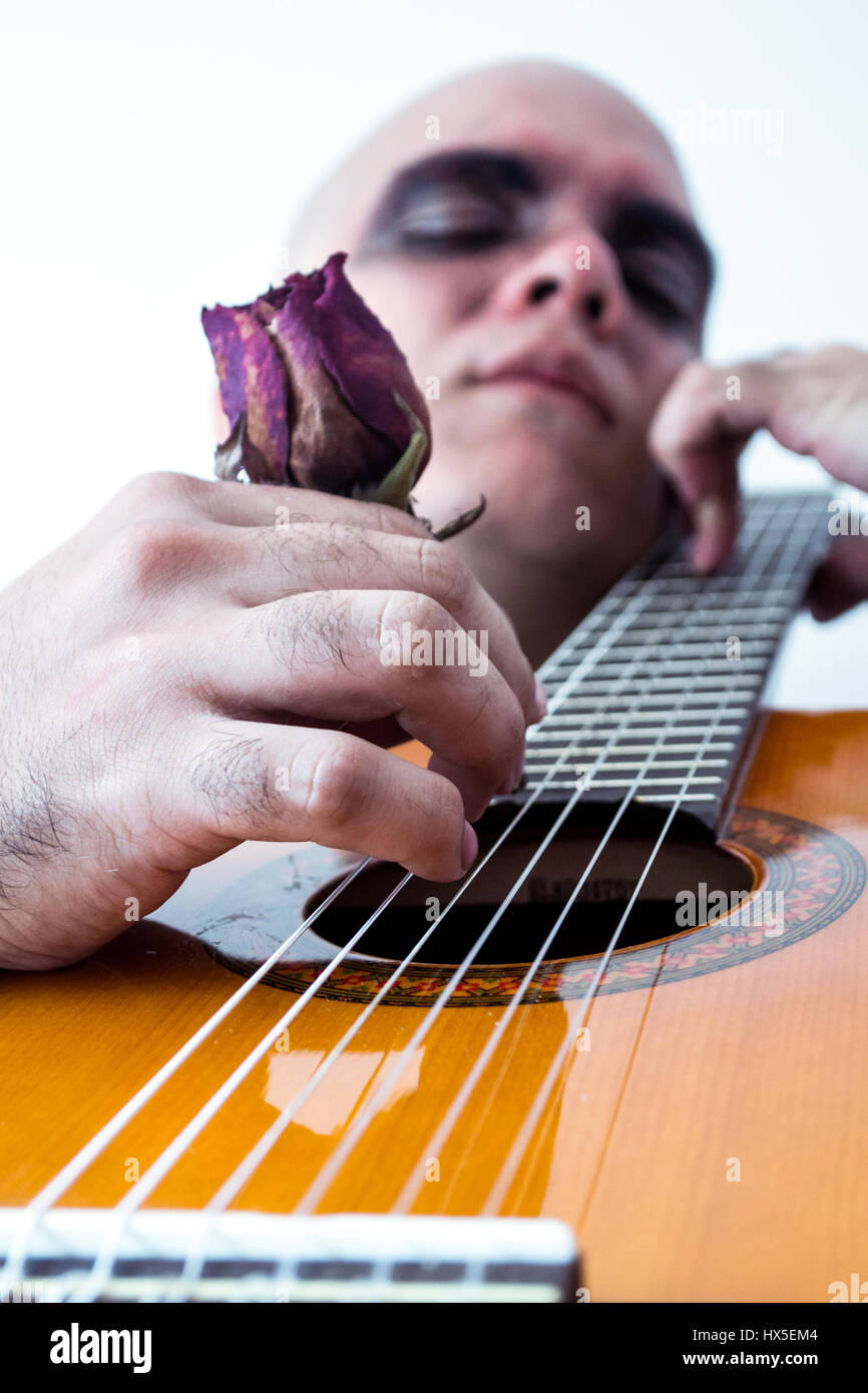 Primo piano di un uomo di suonare una chitarra con un rosso rosa antico Foto Stock