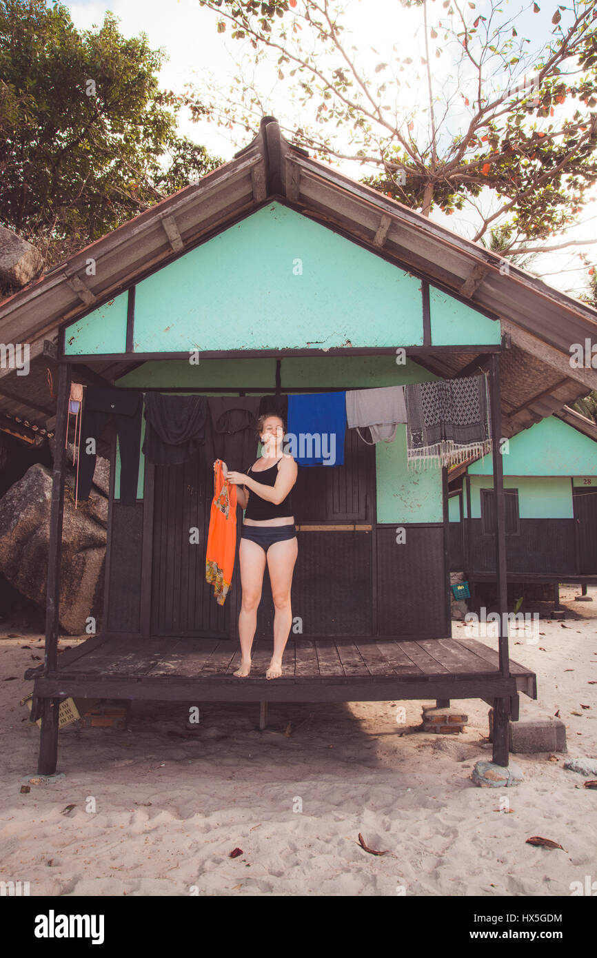 Donna vestiti appesi ad asciugare fuori bungalow sulla spiaggia in Thailandia. Foto Stock