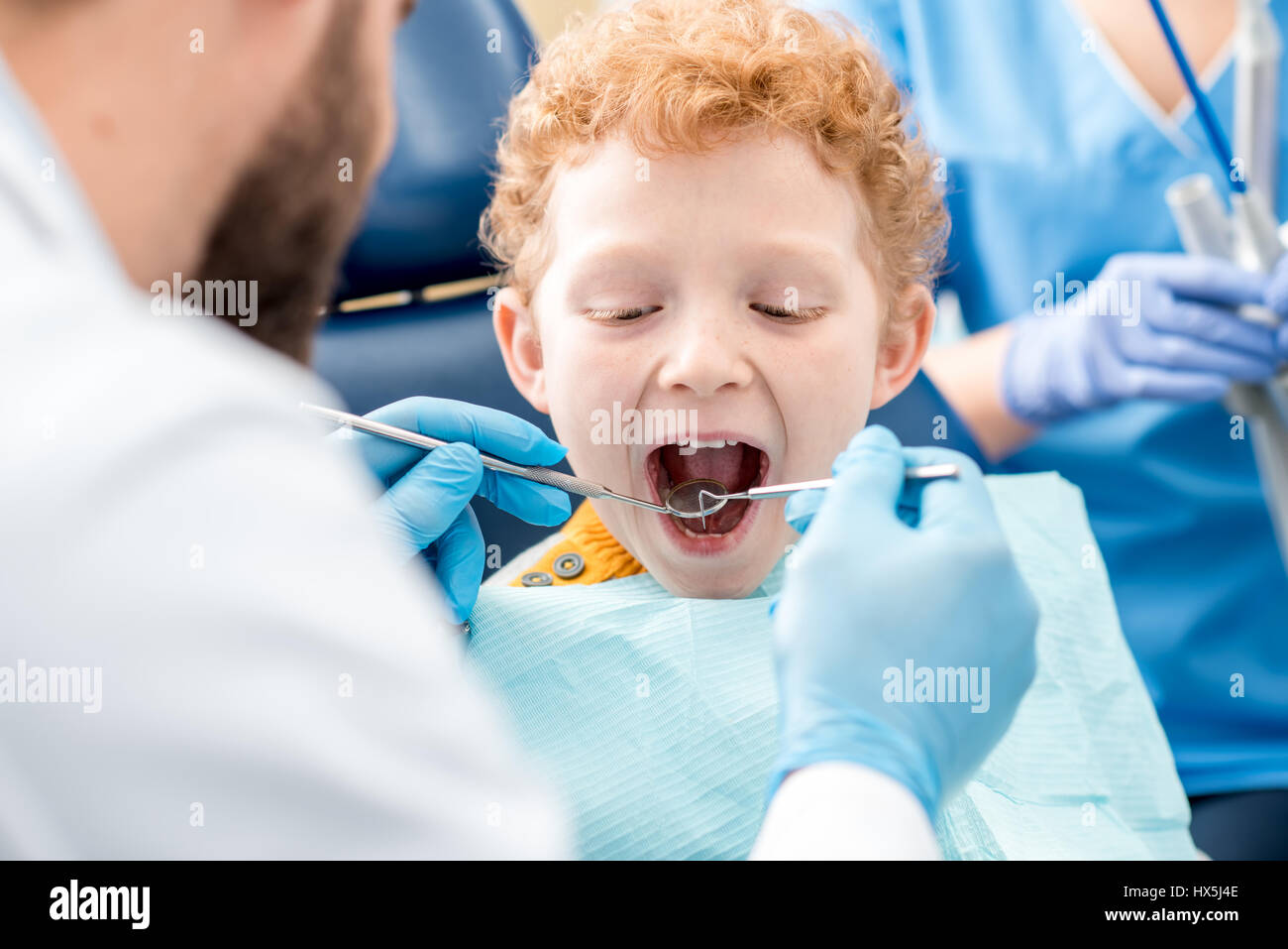 Bambini examinating dentista baby denti di un giovane ragazzo seduto sulla poltrona odontoiatrica presso l'ufficio Foto Stock