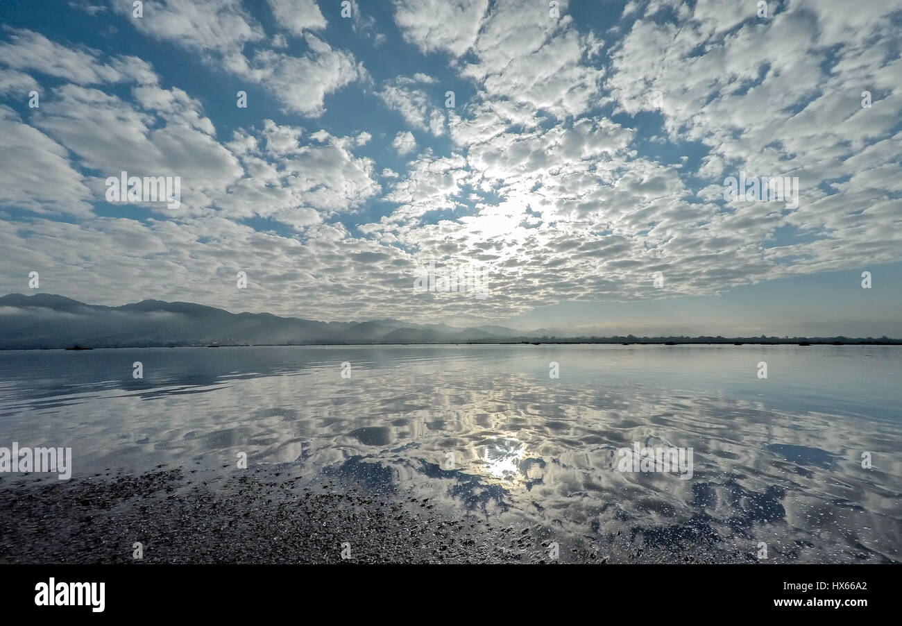 Lago Inle, Myanmar con crazy riflessione cloud oltre la collina dello sfondo. Foto Stock