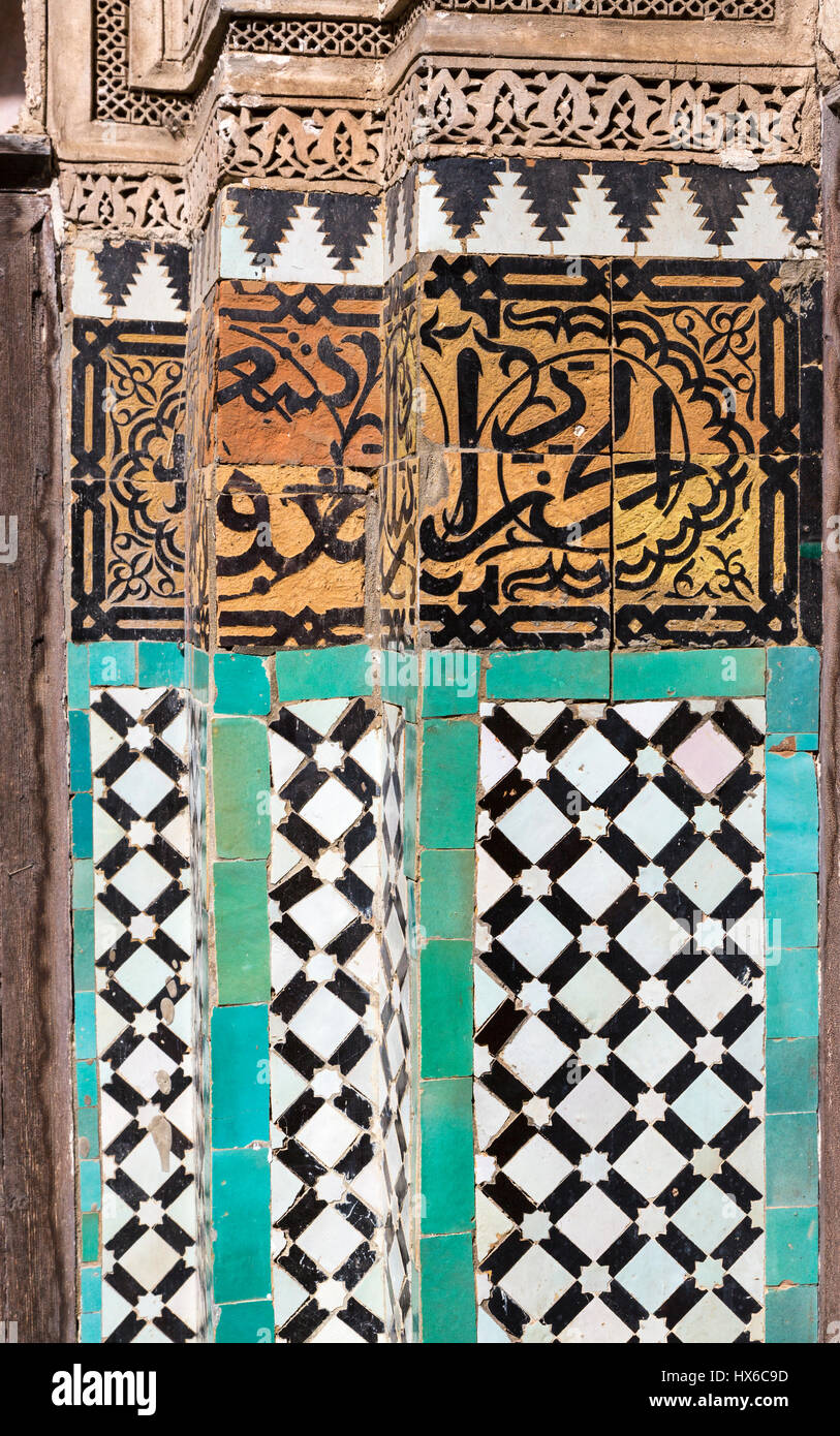 Meknes, Marocco. Medersa Bou Inania, 14th. Secolo. Calligrafia su piastrelle decorative su tre colonne. Foto Stock