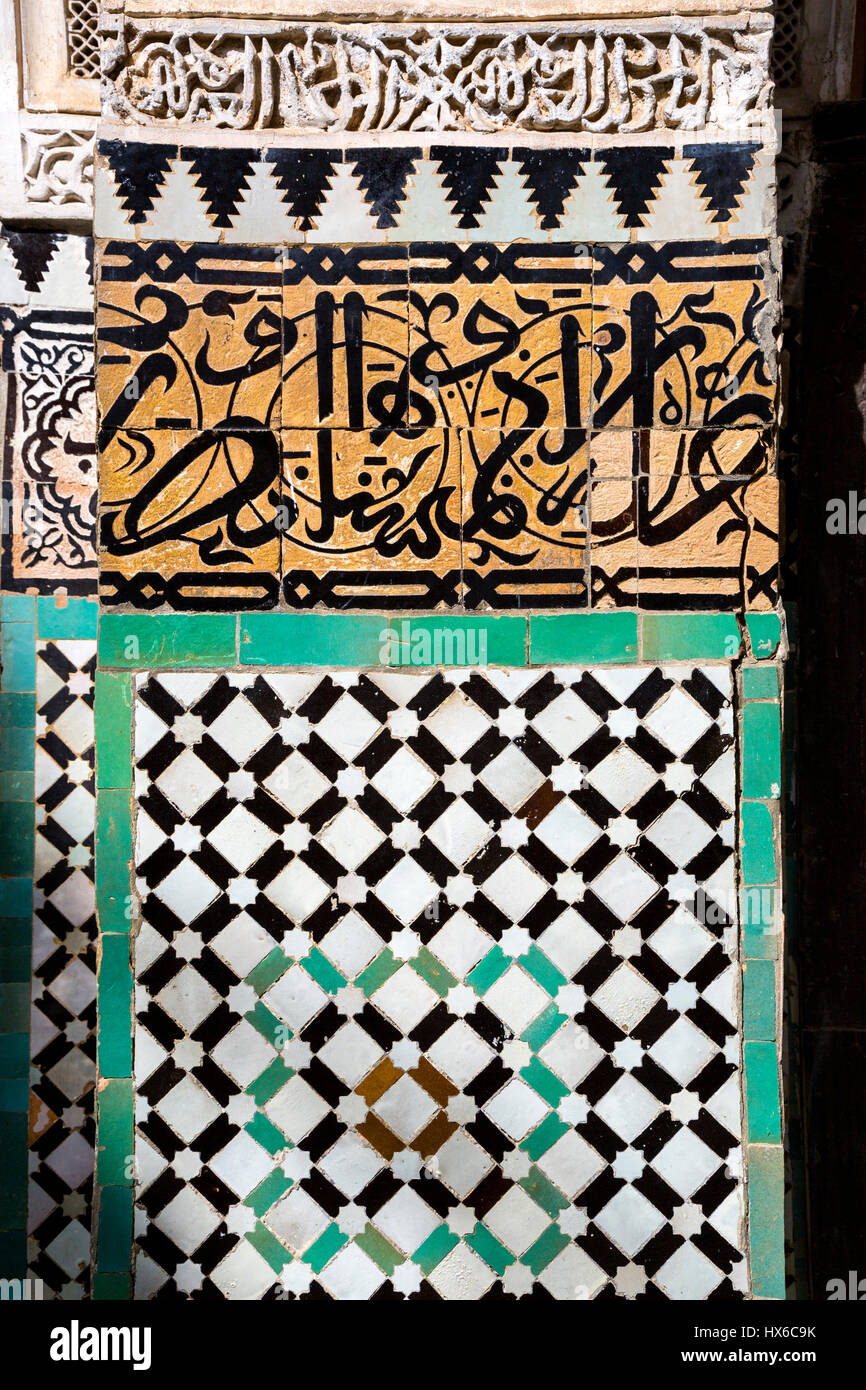 Meknes, Marocco. Medersa Bou Inania, 14th. Secolo. Calligrafia su piastrelle decorative su una colonna. Foto Stock