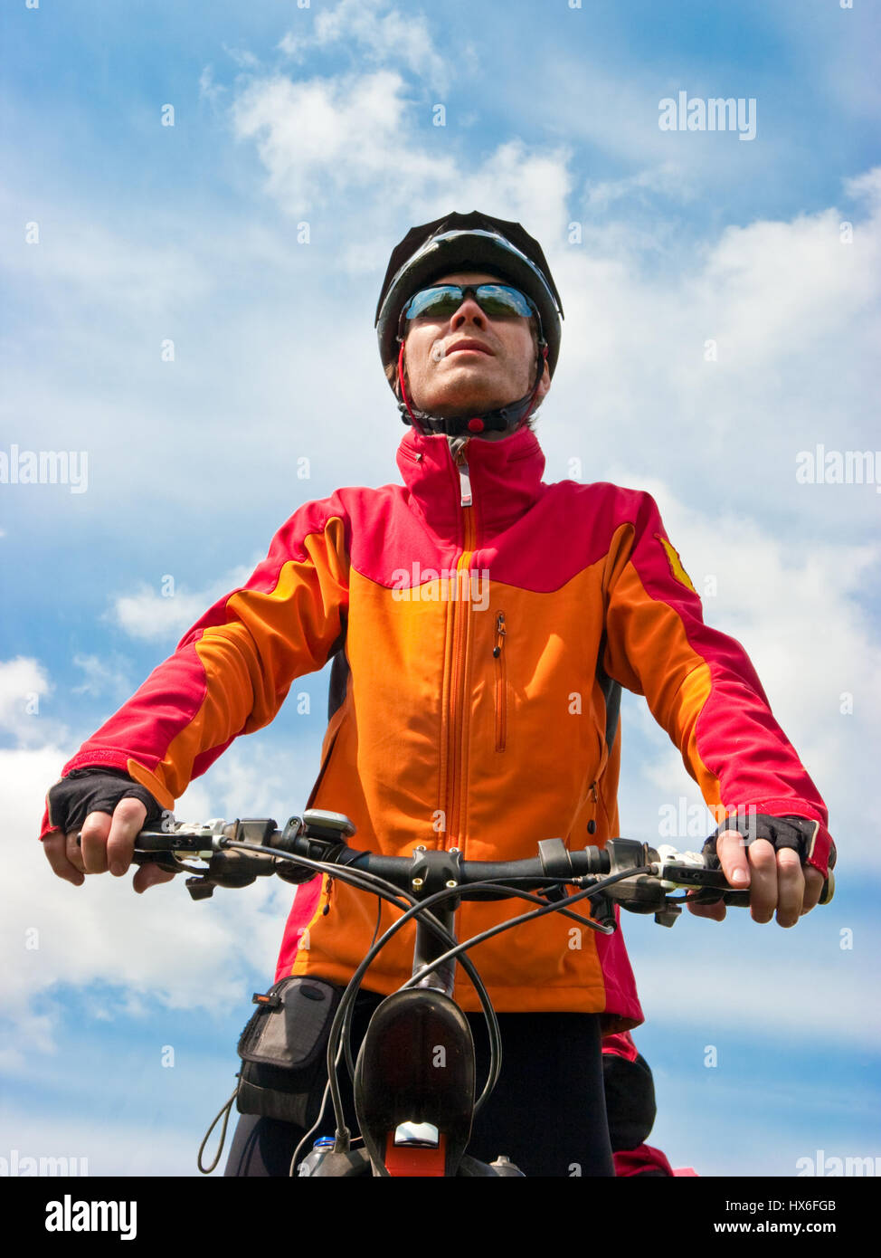 Ritratto di adulto ciclista in mountain bike contro il cielo blu Foto Stock