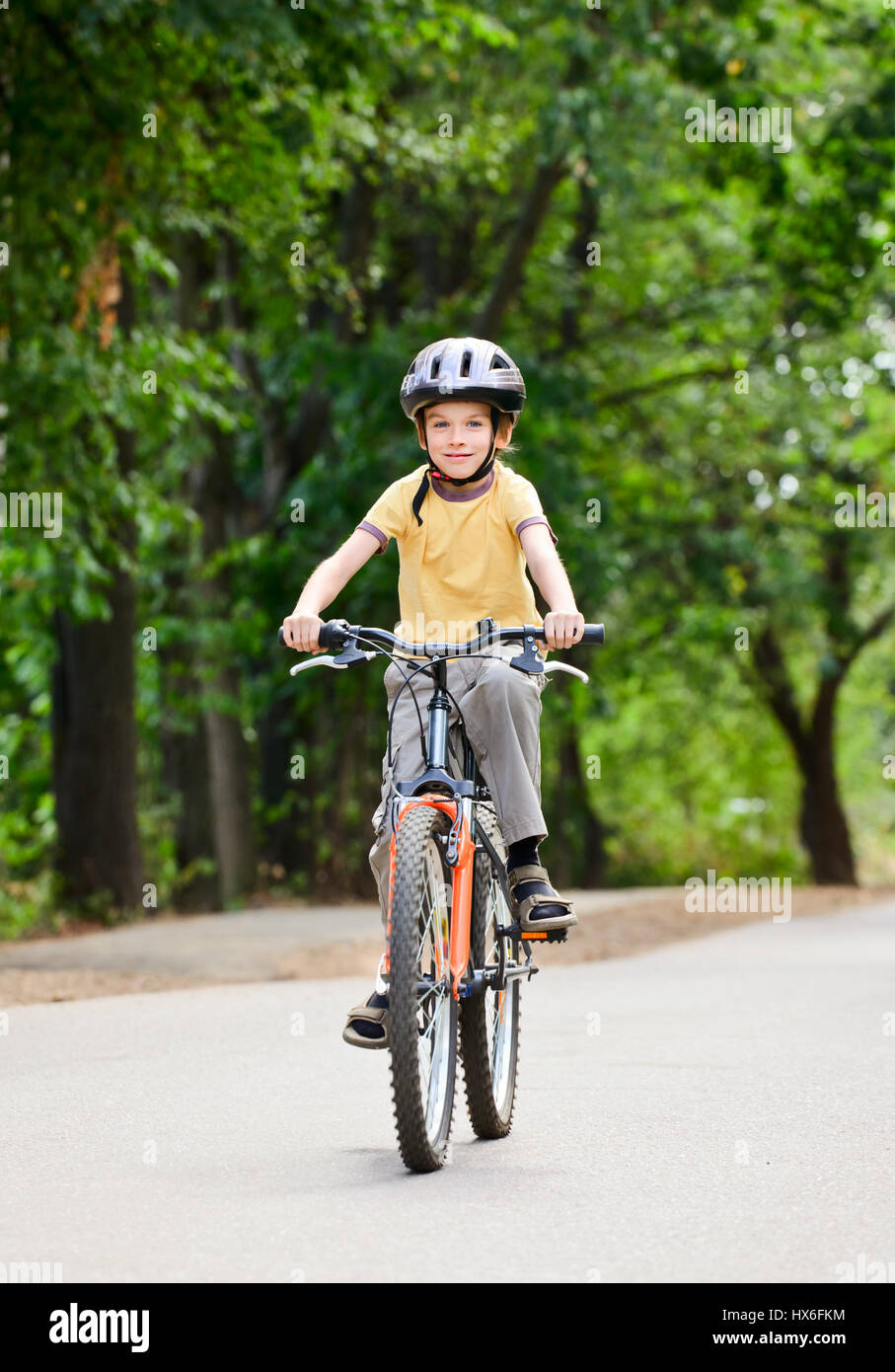 Giovane ragazzo in Bicicletta Equitazione su un giorno di estate Foto Stock