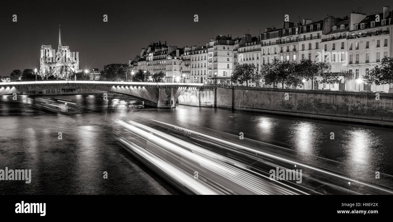 Notre Dame de Paris cathedral illuminato con Senna e La Tournelle Bridge di notte (bianco e nero). Ile Saint Louis, Quai d'Orleans, Parigi Foto Stock