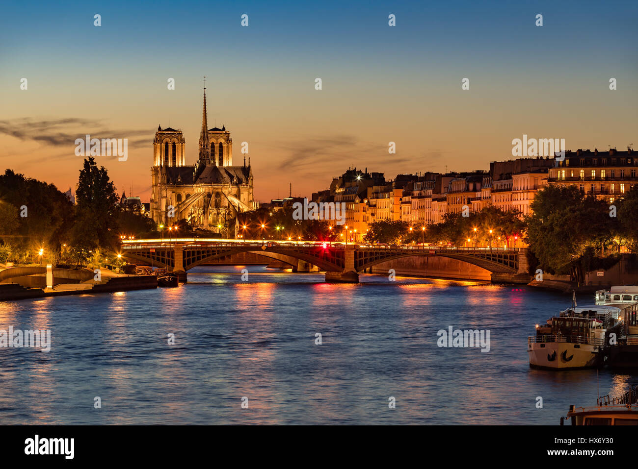 Notre Dame de Paris Cathedral, Senna e l'Ile Saint Louis al crepuscolo. Serata estiva con il ponte di Sully e luci della città di Parigi Foto Stock