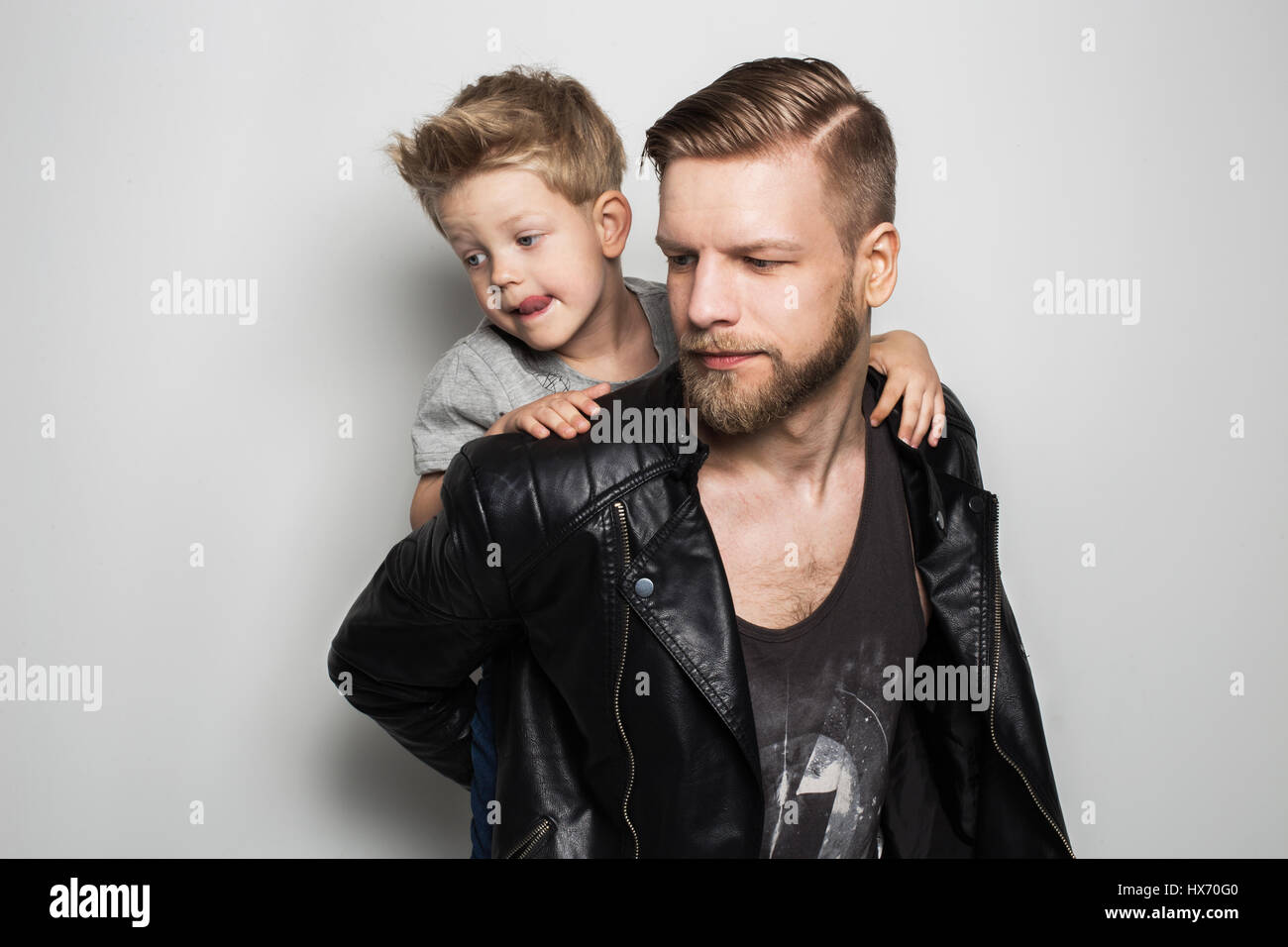 Ritratto di giovane attraente padre sorridente giocando con il suo piccolo figlio carino. Giornata dei padri. Ritratto in studio su sfondo bianco Foto Stock