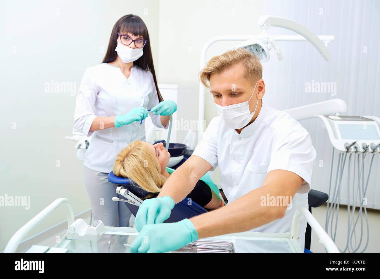 Il dentista uomo e donna assistente sono il trattamento di denti per cli Foto Stock