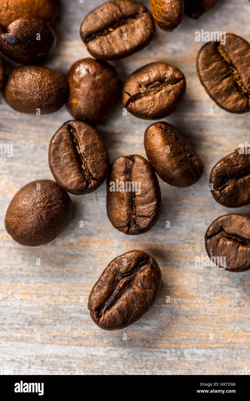 Chicchi di caffè tostati dipinto su tavola di legno Foto Stock