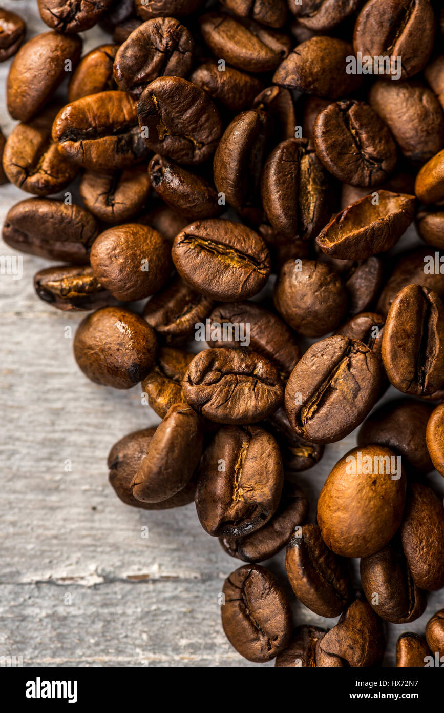 Chicchi di caffè tostati dipinto su tavola di legno Foto Stock