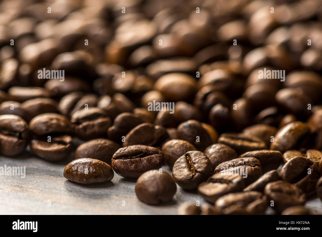 Chicchi di caffè tostati dipinto su tavola di legno Foto Stock