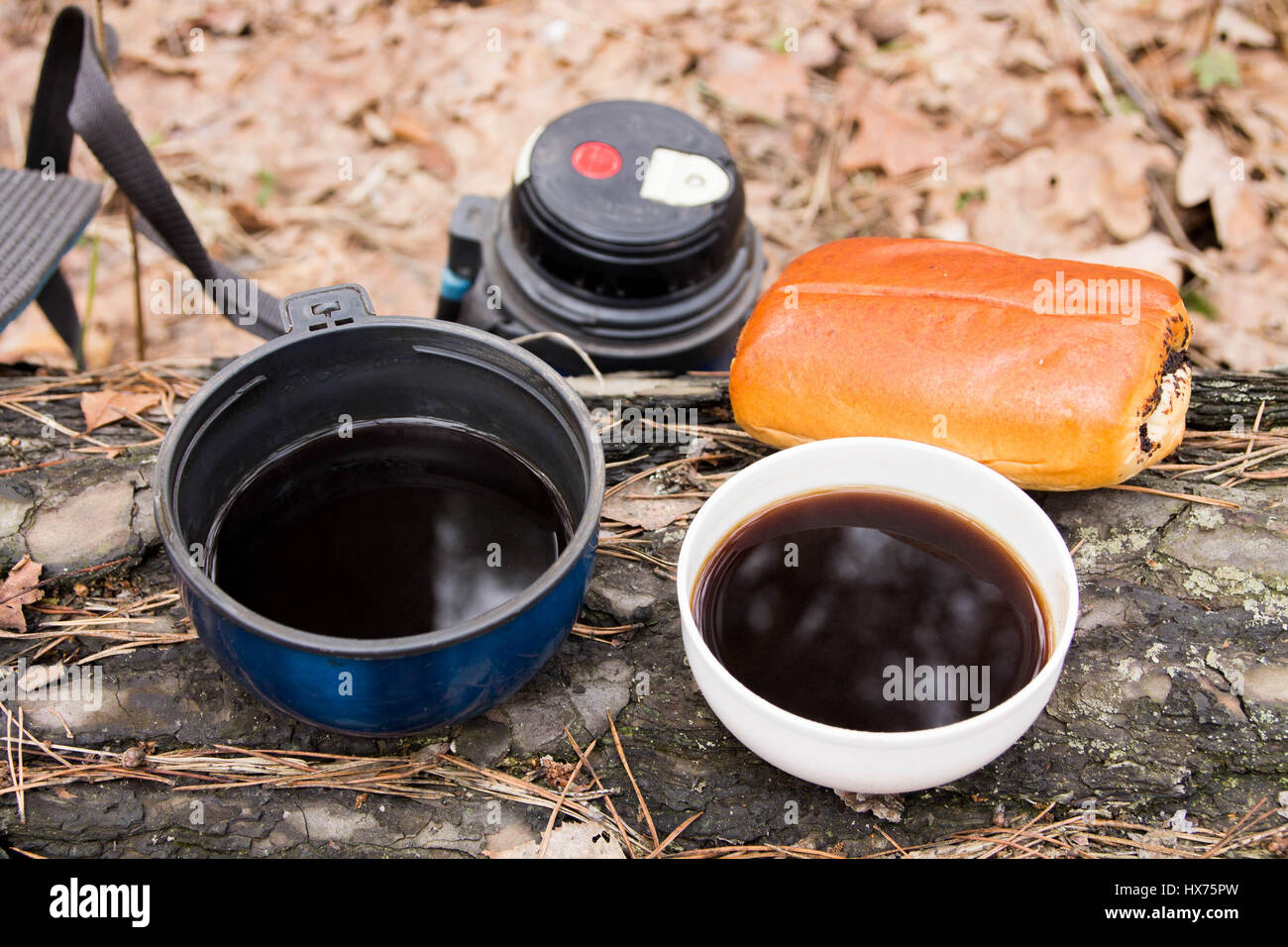 Due tazze di caffè con una pagnotta. Pausa caffè. Merenda nel bosco. Foto Stock