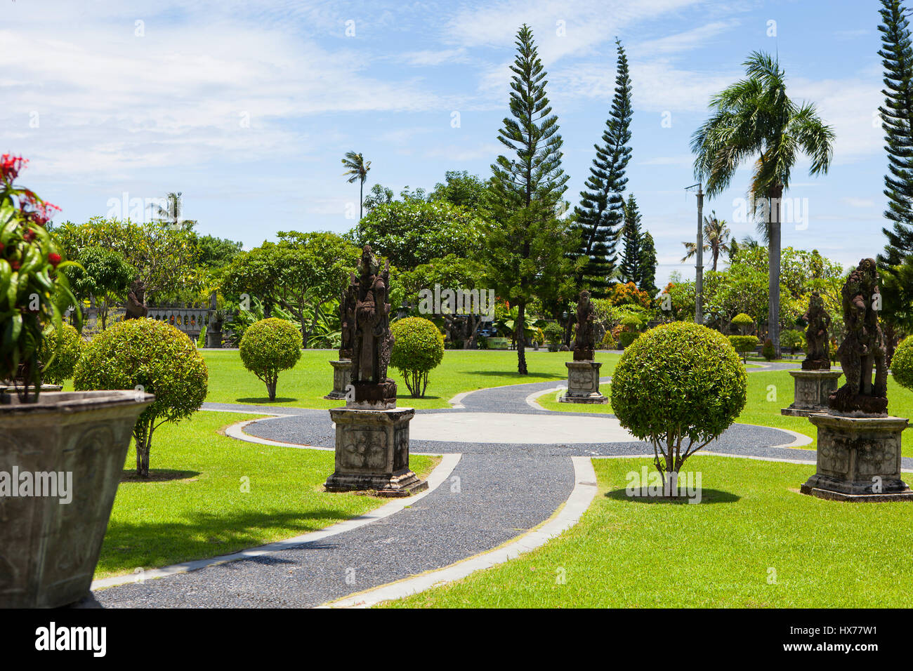Un percorso di pietra e arbusti di varie forme nel parco esotico nei tropichi tirta gangga Palazzo acqua Taman Ujung Foto Stock