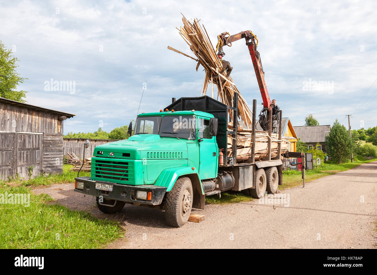 Novgorod, Russia - Luglio 25, 2016: Log manipolatore idraulica legname scaricato dal carrello in giorno di estate Foto Stock