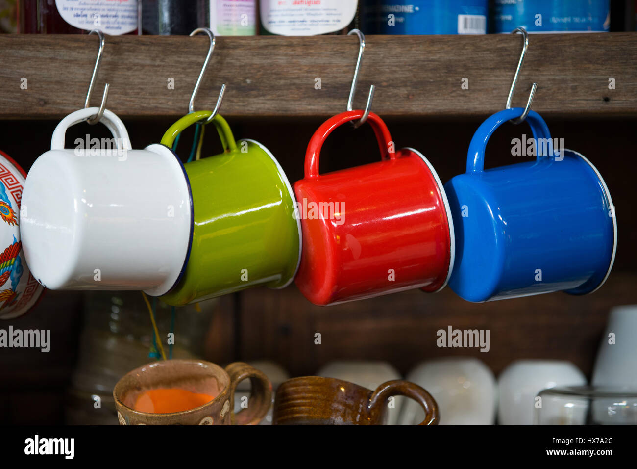 Colorato in ferro zincato mug appesa in un cafe Foto Stock