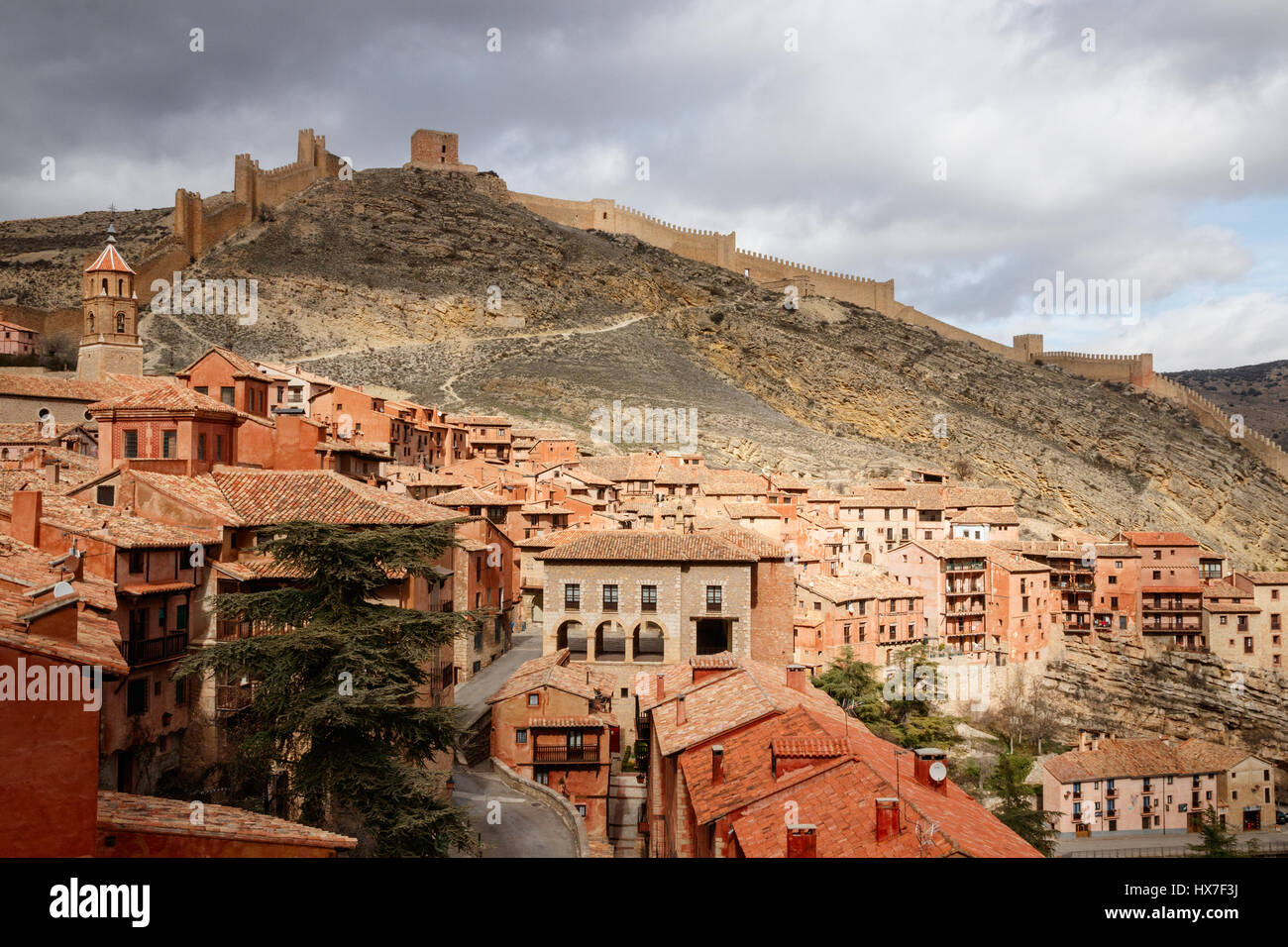 Bellissima vista della città medievale Albarracin nella luce del sole con le colline e le mura della città sullo sfondo sotto un cielo nuvoloso. Teruel, Spagna. Foto Stock
