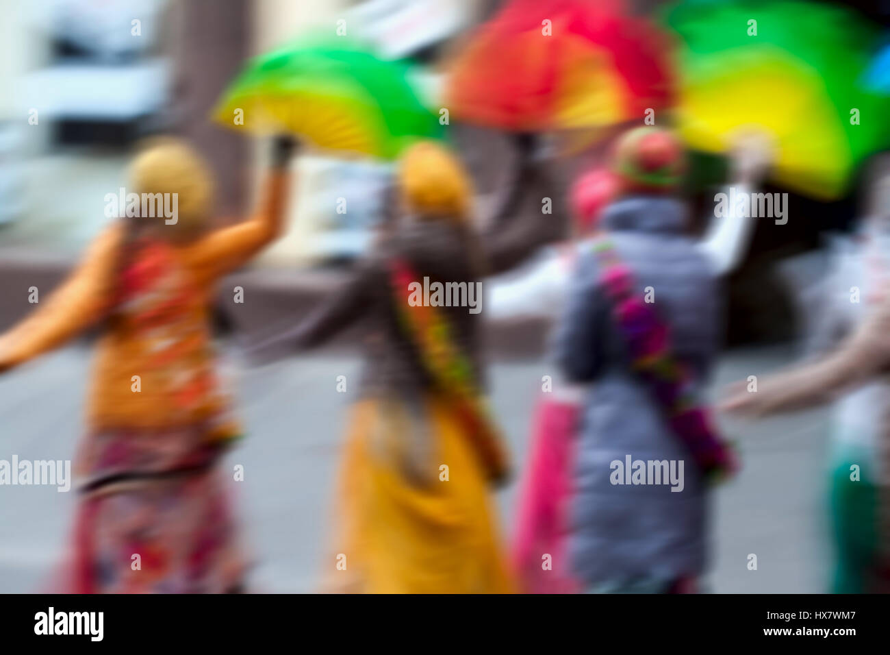 Le ragazze in abiti luminosi, gruppo di Hare Krishna circolazione di cantare e ballare per le strade della città con le parole Hare Krishna. Abstract movimento sfocati sfocato Foto Stock