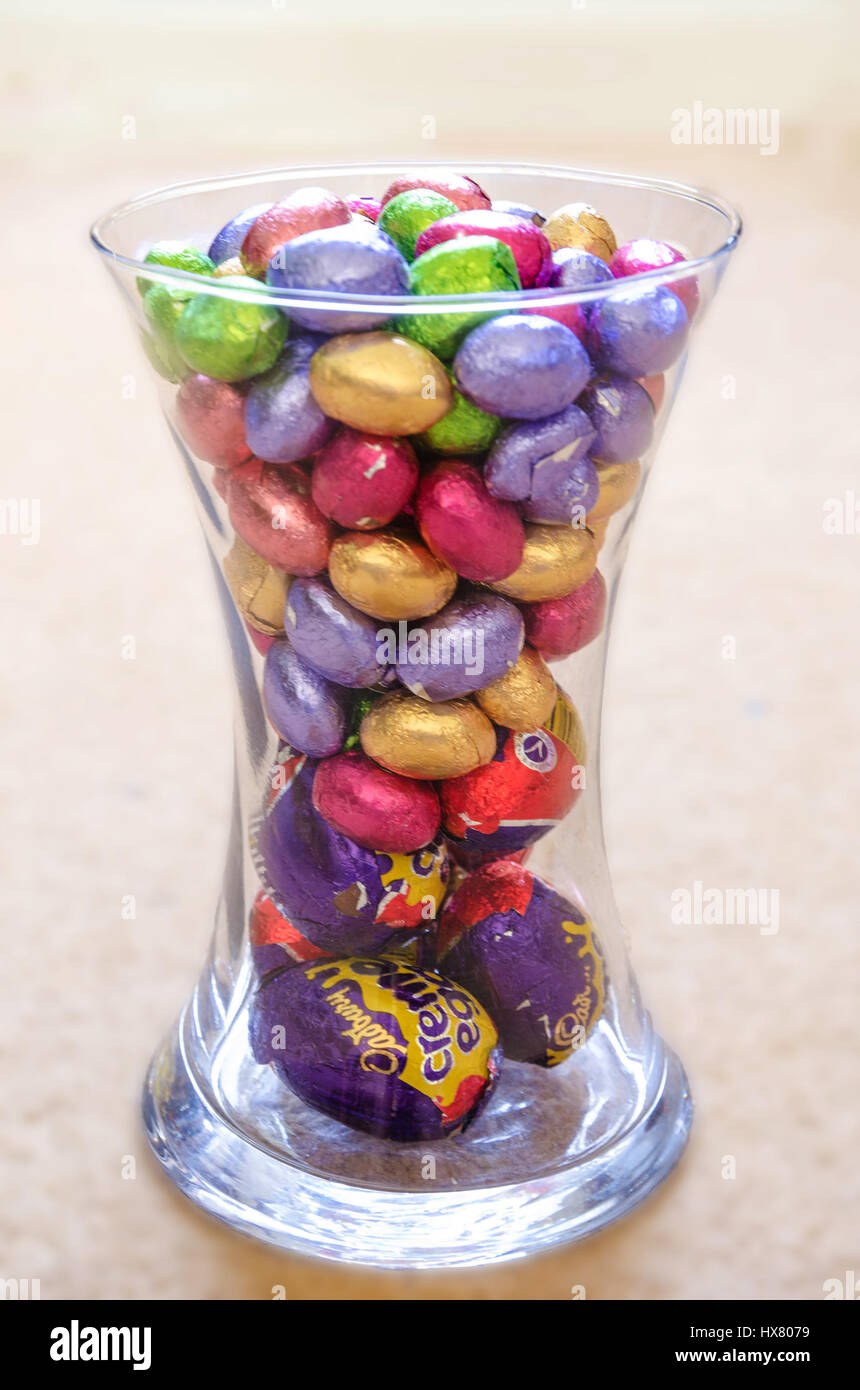 Mini uova di pasqua di cioccolato avvolto in Colorati luminosamente involucri di carta metallizzata in un vaso di vetro. Foto Stock