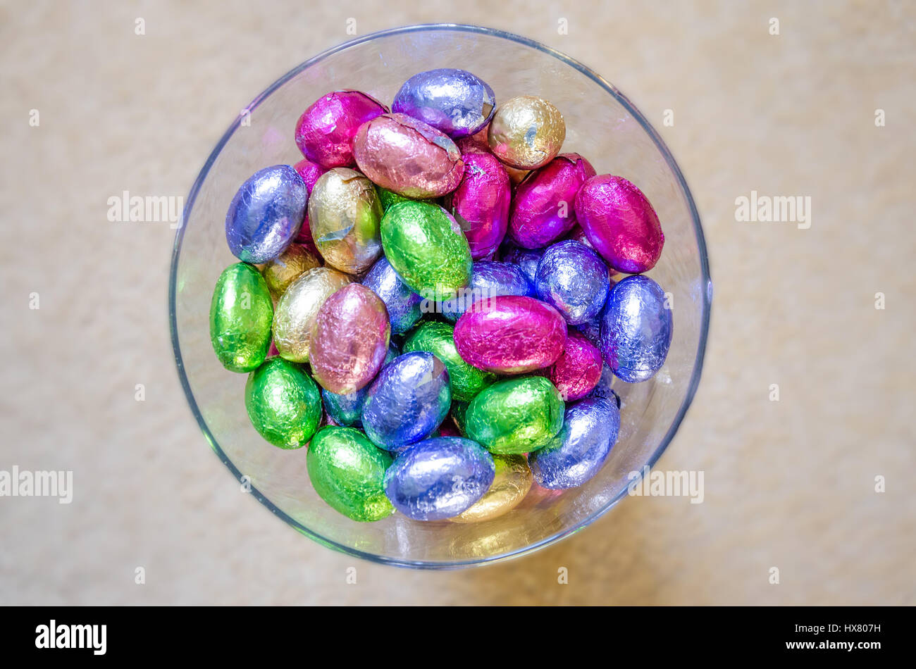 Mini uova di pasqua di cioccolato avvolto in Colorati luminosamente involucri di carta metallizzata in un vaso di vetro. Foto Stock