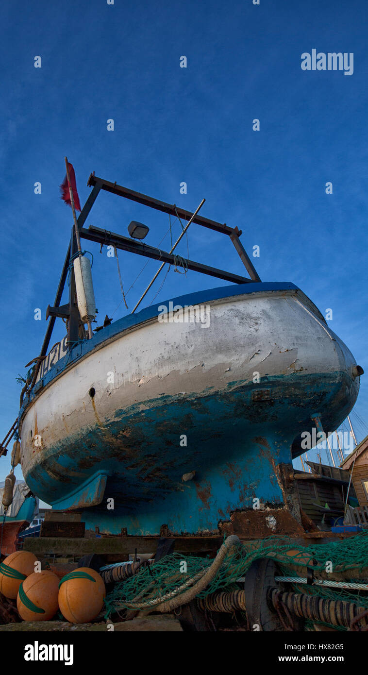 Una vecchia imbarcazione in fase di manutenzione in un bacino a secco nel Suffolk, Inghilterra. Foto Stock