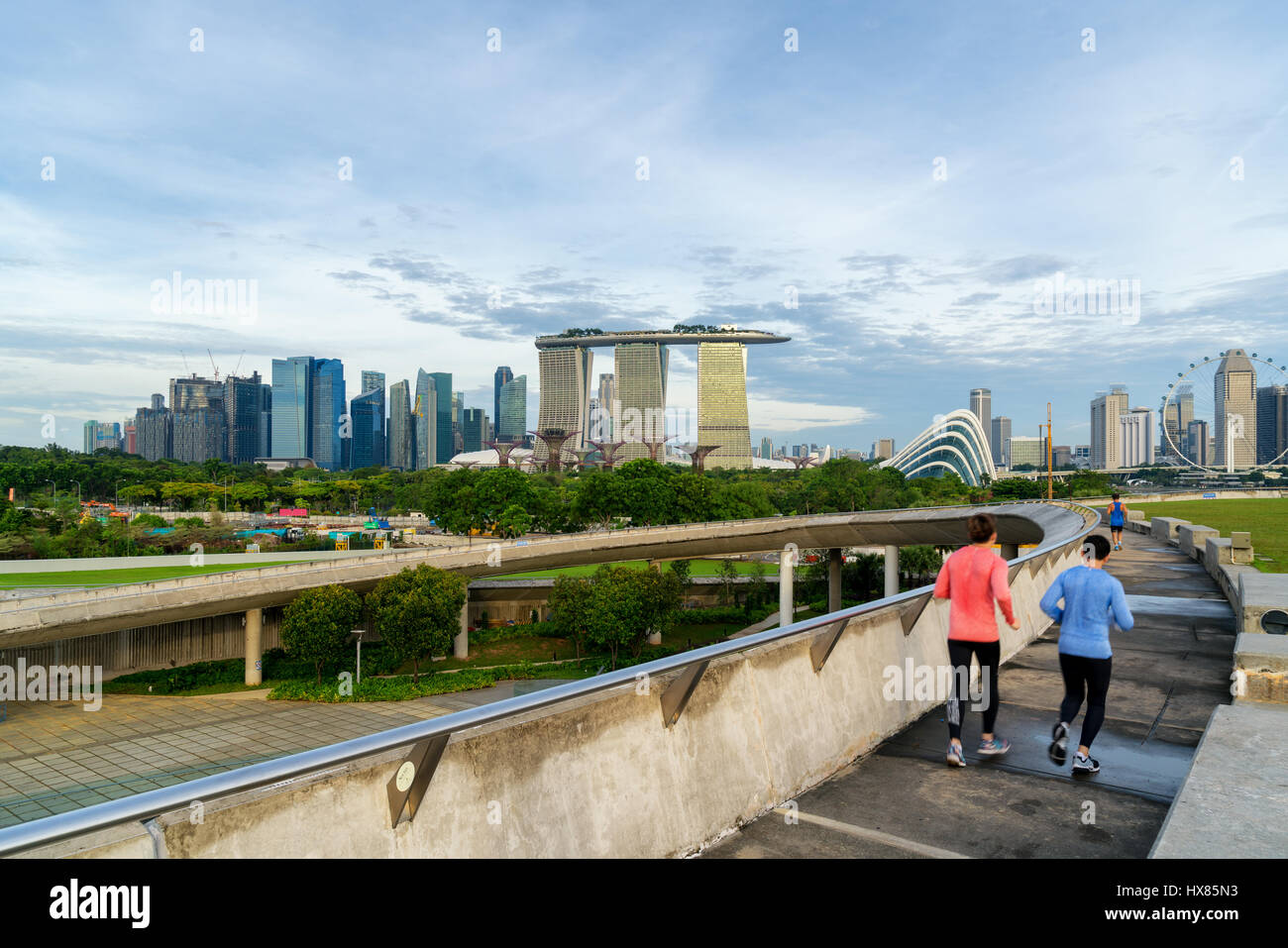 Persone jogging al mattino in Singapore. Singapore Downtown Core in background. Foto Stock