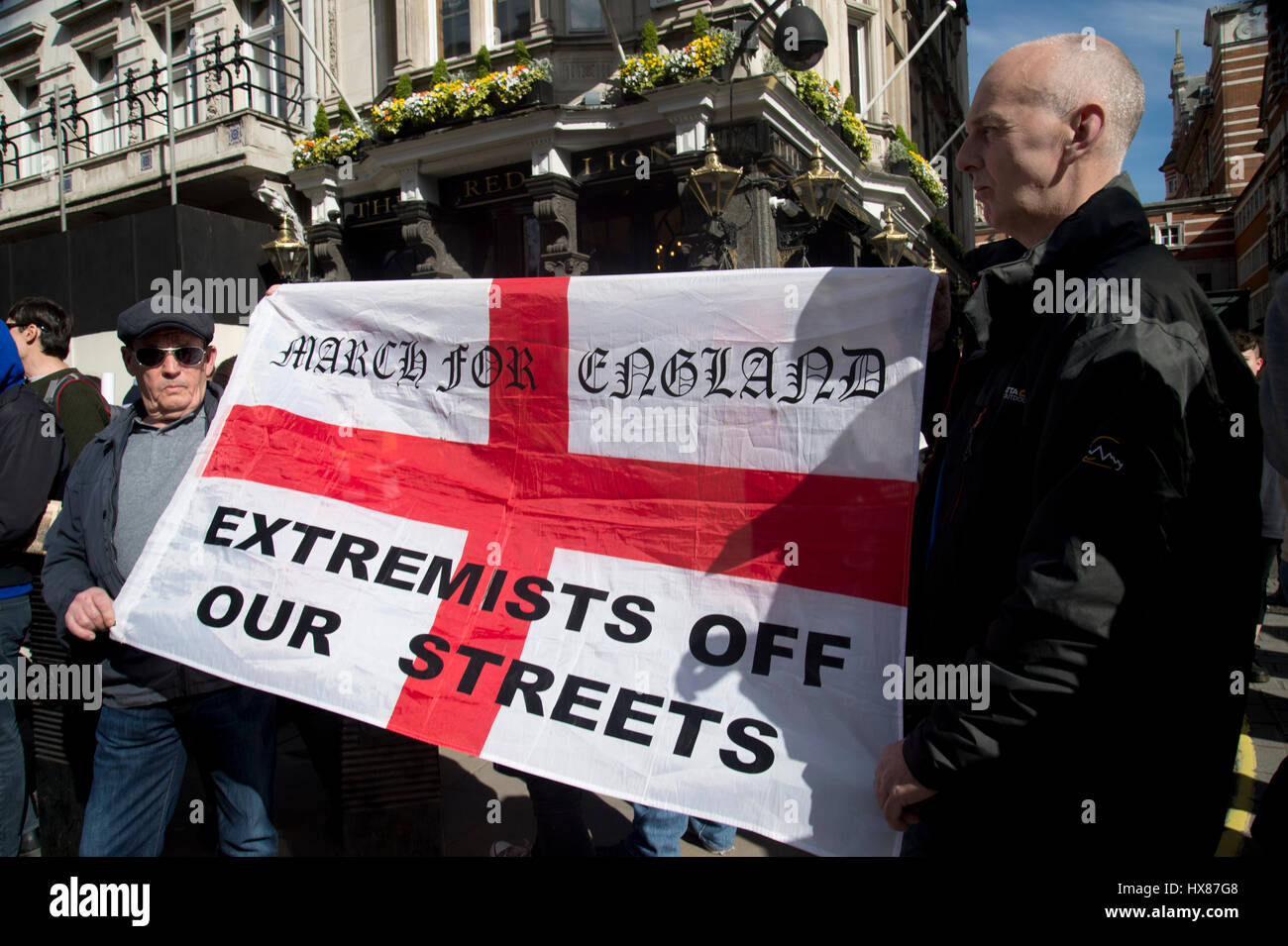 Unite per l'Europa marzo al Parlamento il 25 marzo 2017 , Londra. Un piccolo gruppo di pro Brexit manifestanti stare dietro un rosso e bianco bandiera inglese Foto Stock