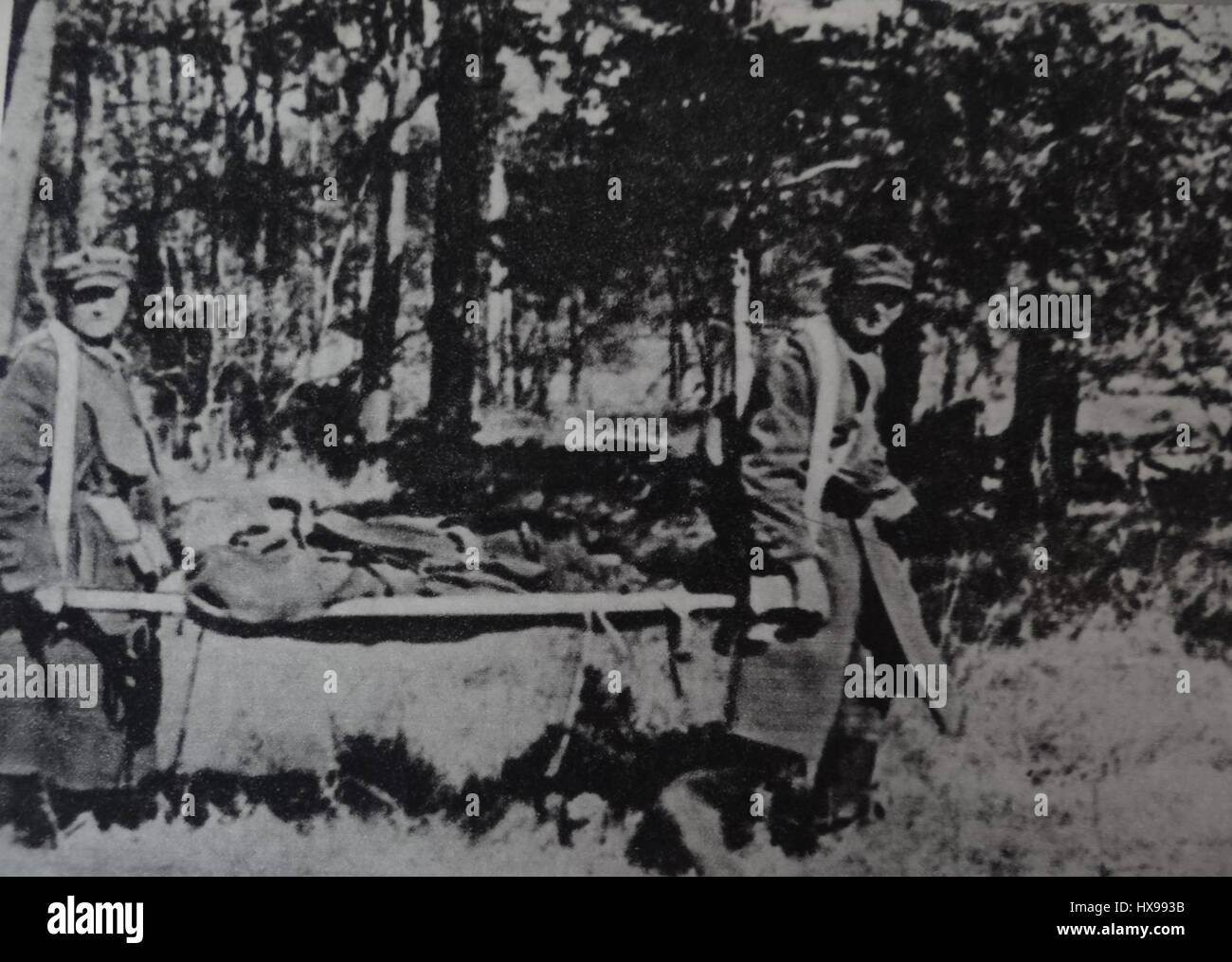 «Sanitariusze W rejonie bazy szpitalnej 12 PRSzCH W Ruszowie» è una fotografia storica che documenta le attività dei medici militari nei pressi di una base ospedaliera a Ruszów, Polonia. L'immagine cattura la dedizione e il servizio del personale medico durante un momento critico della storia, offrendo uno sguardo sul loro ruolo nel fornire aiuto e supporto in tempi di conflitto. Foto Stock