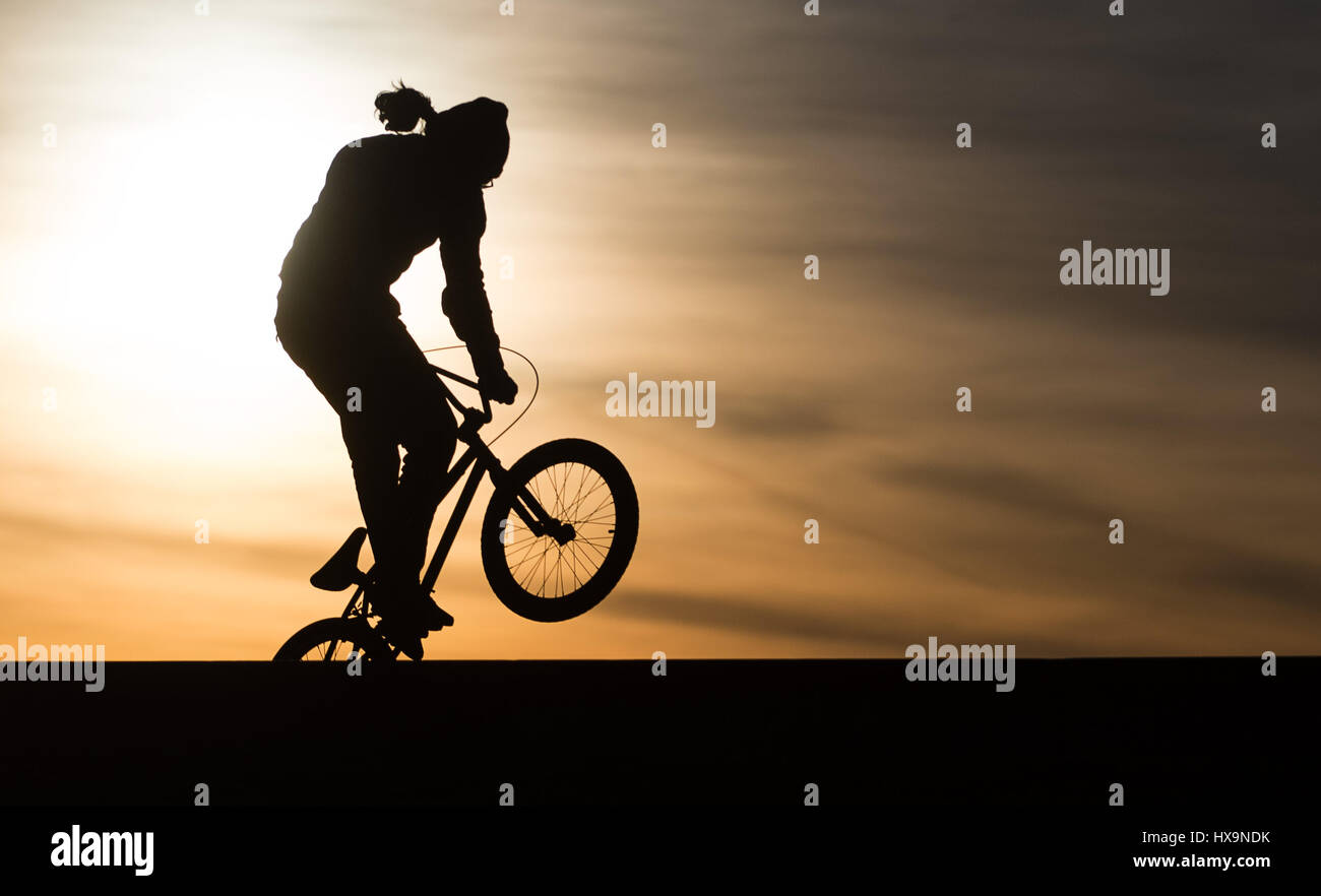 Berlino, Germania. 25 Mar, 2017. Una BMX biker in azione al tramonto a Tempelhofer Feld (lit. Campo di Tempelhof di Berlino, Germania, 25 marzo 2017. Foto: Sebastian Gollnow/dpa/Alamy Live News Foto Stock