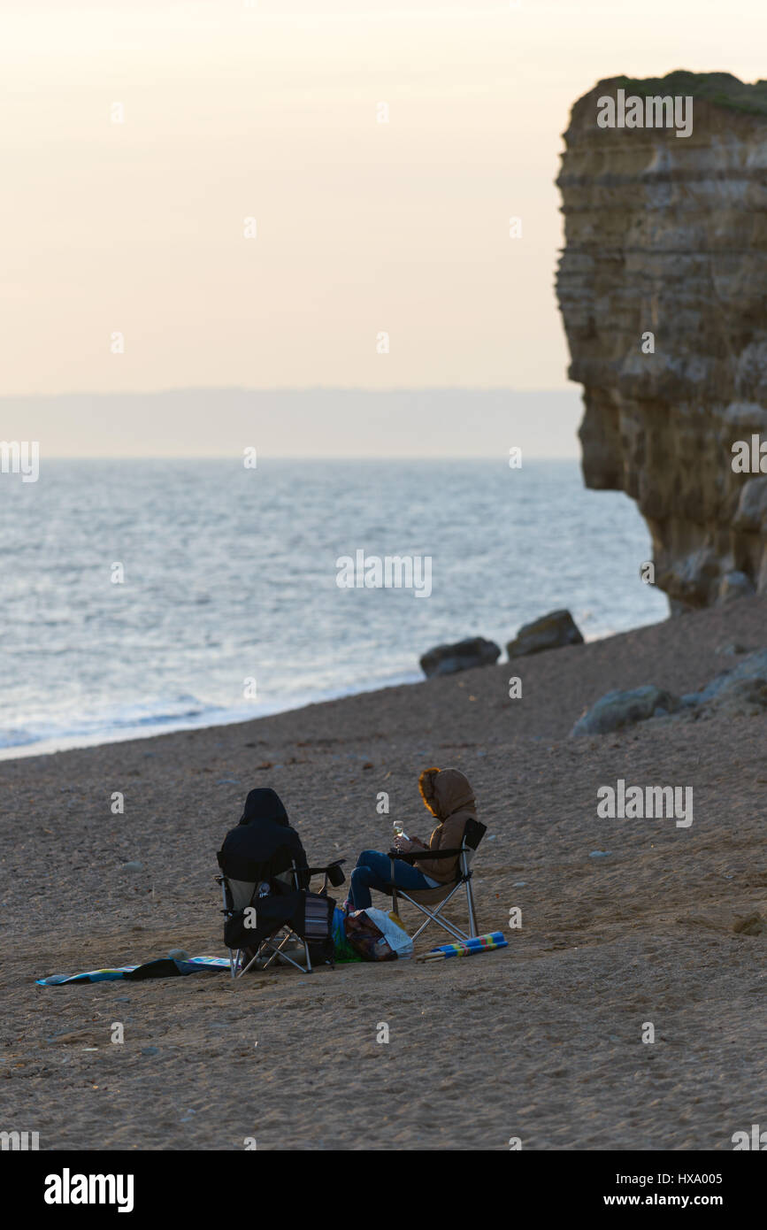 Burton Bradstock, Dorset, Regno Unito. Il 26 marzo 2017. Due donne gustare un bicchiere di vino confezionato in loro vestiti in un ambiente fresco e colorato al fine di un soleggiato e caldo giorno in poi costa sud. Il primo giorno di BST su Mothering Domenica. © Dan Tucker/Alamy Live News Foto Stock
