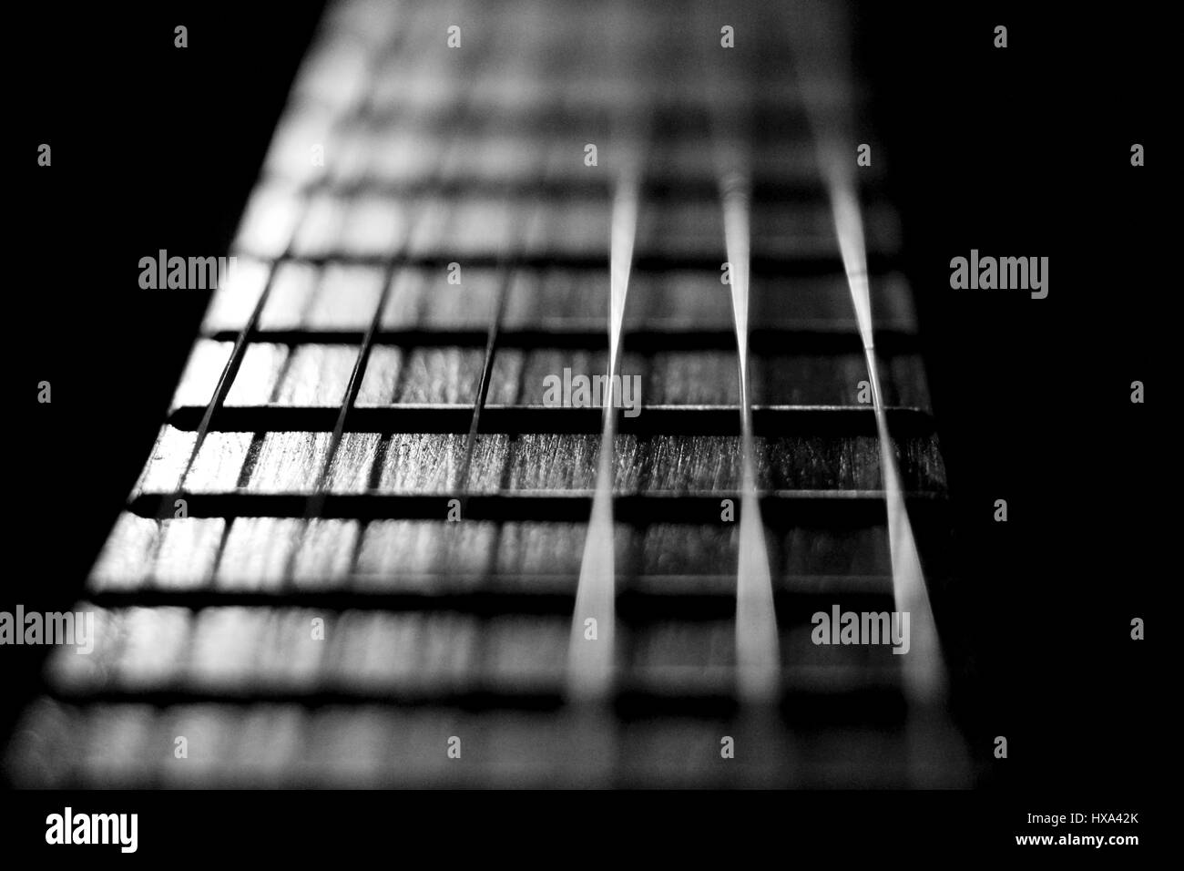 Concerto di strumento musicale le corde di una chitarra in bianco nero argento. Primo piano dello strumento a corda per classic rock pop isolati su sfondo nero. Foto Stock