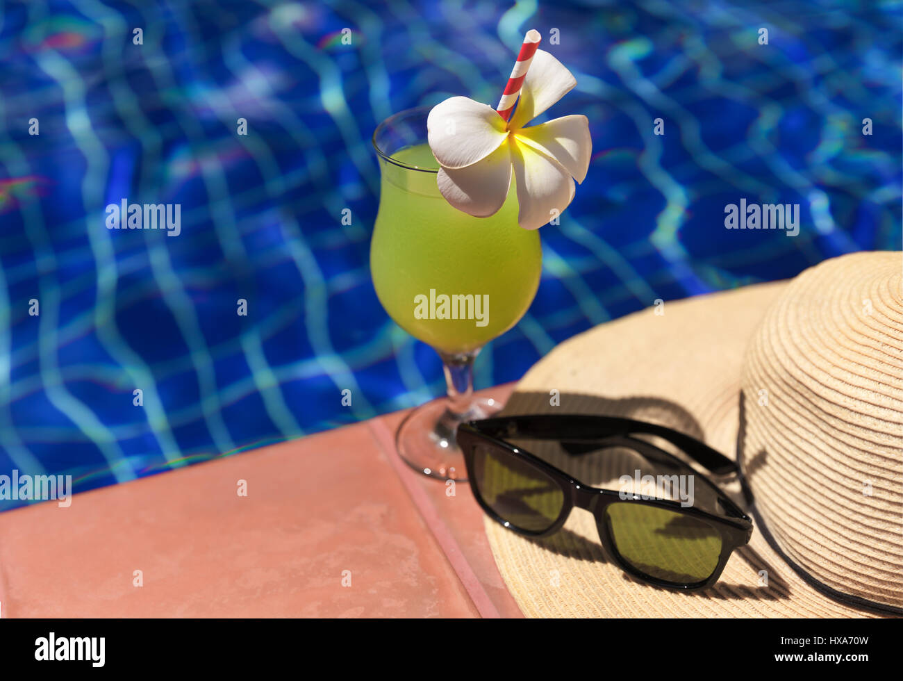 Guaiava verde succo fresco drink smoothie cocktail, occhiali da sole e cappello di paglia vicino alla piscina - vacanza estiva concept Foto Stock