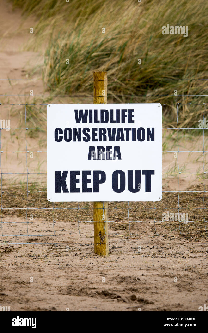 Un segnale di avvertimento per i visitatori di Talacre beach nel Galles del Nord per informare i visitatori di Wildlife Conservation Area e per tenere fuori. Foto Stock
