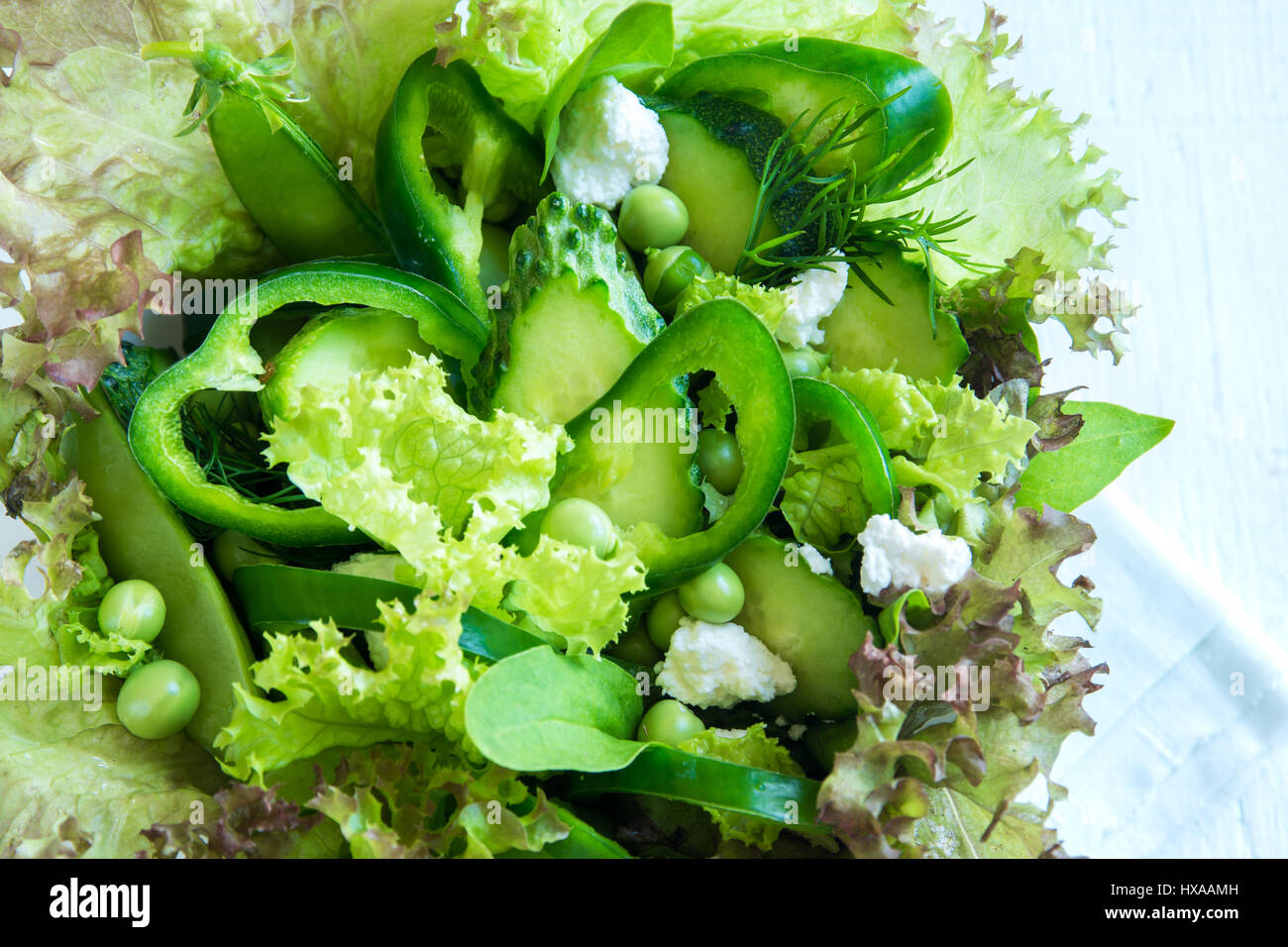 Organico verde mista insalata di verdure con formaggio feta e piselli primavera nella ciotola di legno close up - Dieta sana Organica Vegana cibo vegetariano insalata di pasto Foto Stock