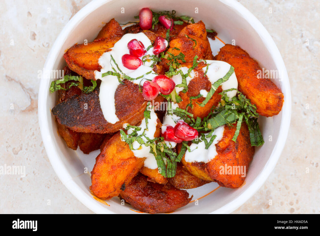 Ristoranti mediorientali - saute di patate con paprika affumicato e i semi di melograno, - Esempio di Cibo Vegetariano o Vegano cibo, REGNO UNITO Foto Stock