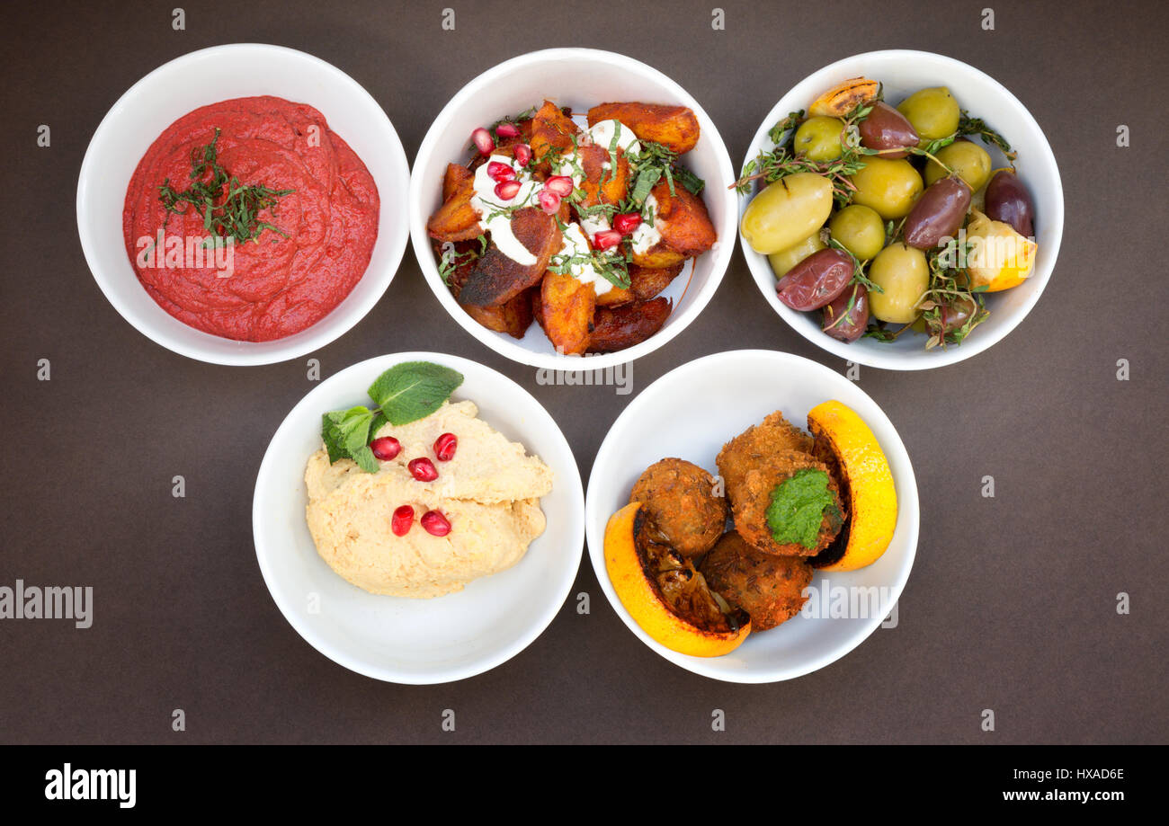 World Food; bocce di diversi ristoranti mediorientali - barbabietole muhamarra, rosolare le patate con melograno, olive, Hummus e zucca frittelle di riso Foto Stock