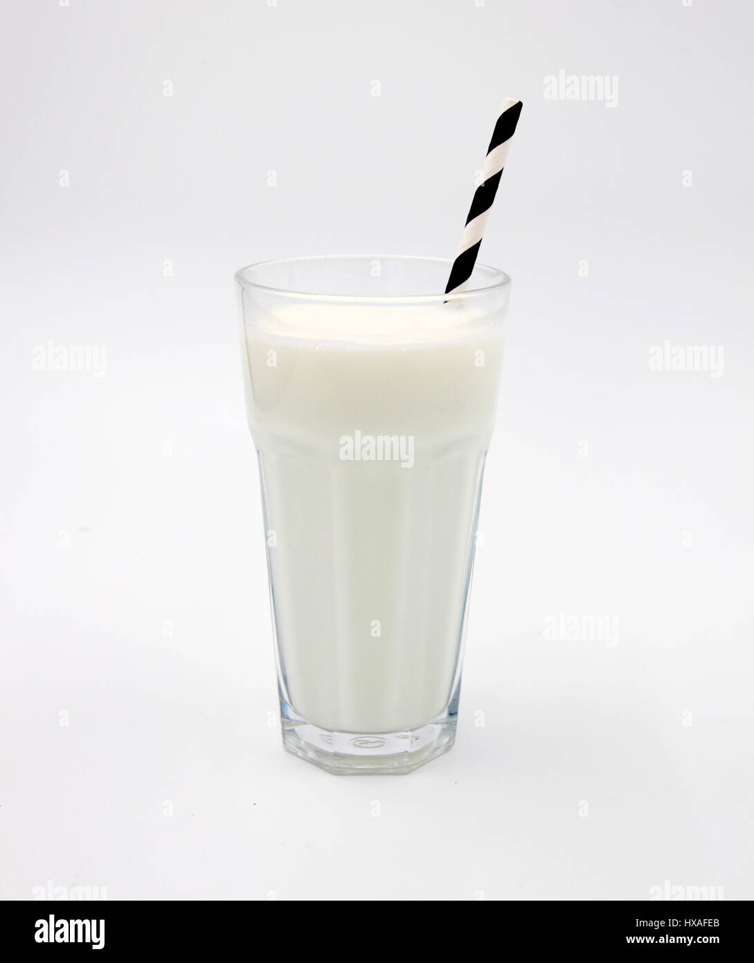 Latte con vetro bianco e nero a strisce di paglia sullo sfondo - isolato Foto Stock