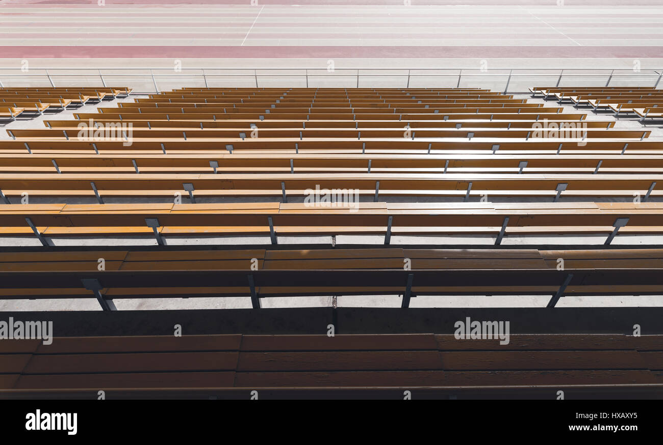 Ampio angolo di visione di simmetria delle righe di colore giallo in legno stadium sedi visto da dietro Foto Stock