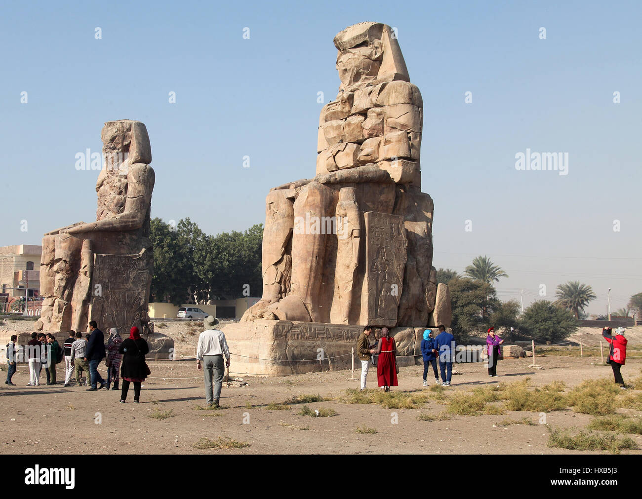 I turisti guardando l'iconica Colossi di Memnon sulla riva occidentale di Luxor Foto Stock