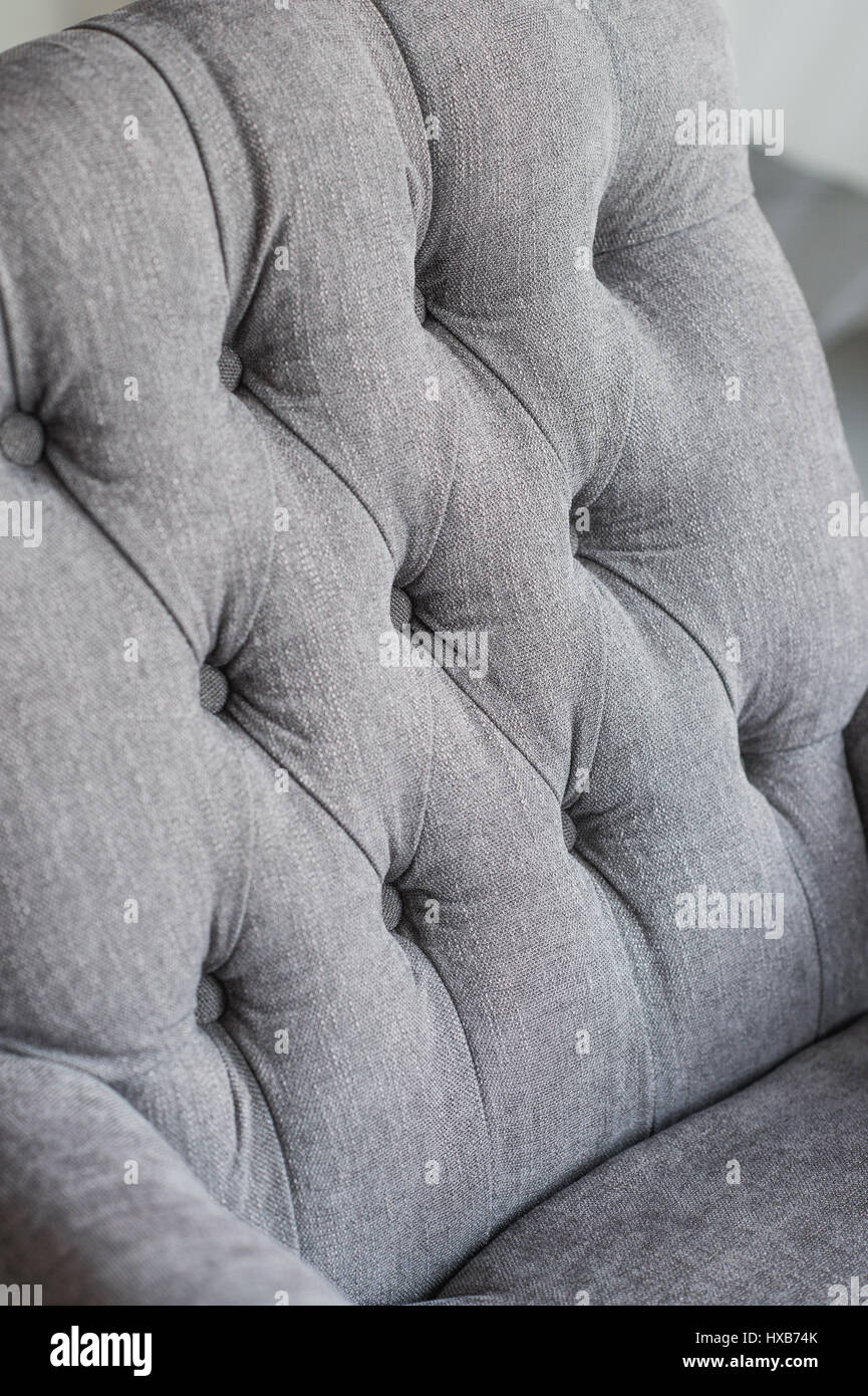 Seamless texture di sfondo close up di un divano grigio indietro con il pulsante dettagli su un panno spesso. Foto Stock