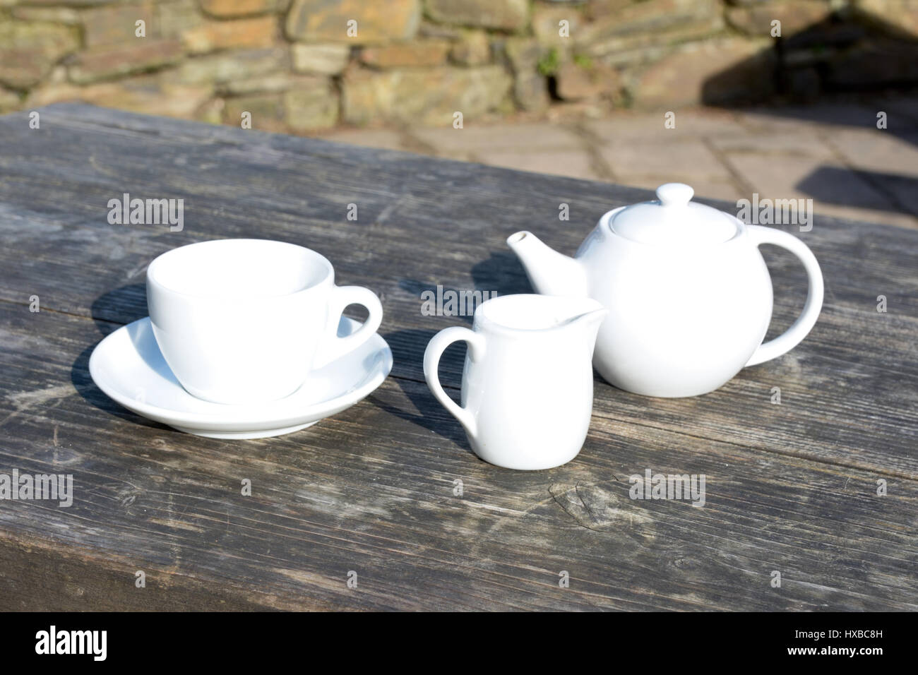 Teiera tazza da caffè con piattino più un bricco per latte su legno tabella cafe Foto Stock