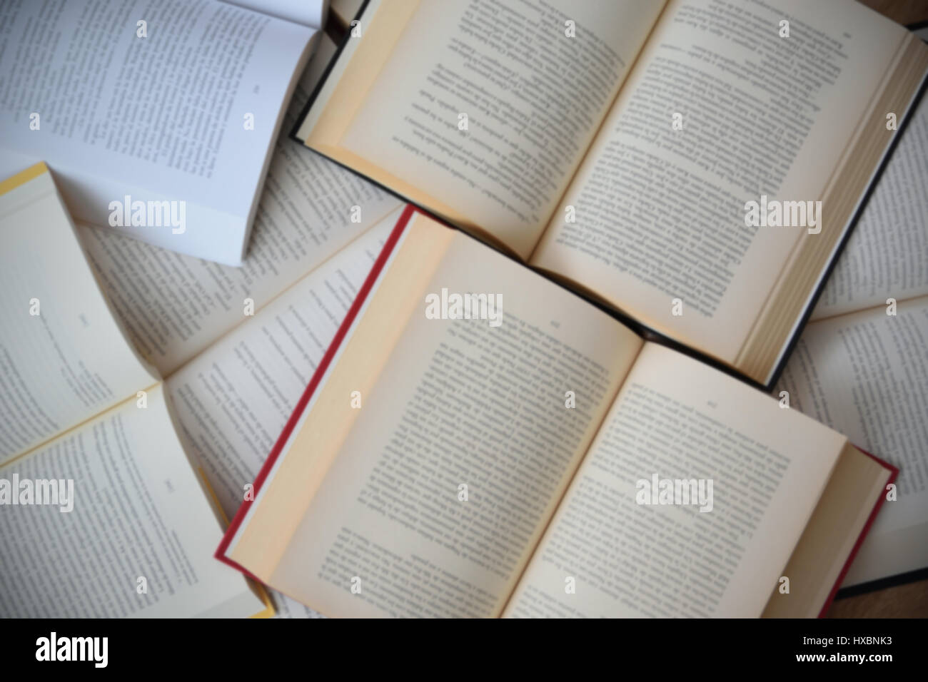Alcuni libri aperti sullo sfondo. Tabella disordinato in una libreria Foto Stock