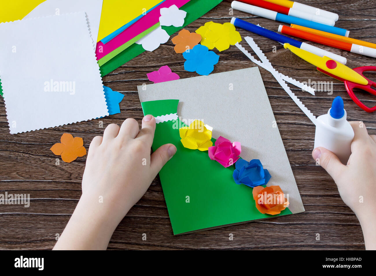 Un bambino è in possesso di un biglietto di auguri con fiori per la Festa della mamma. Per i bambini il progetto arte, artigianato per bambini. Fatte a mano. Craft per bambini. Foto Stock