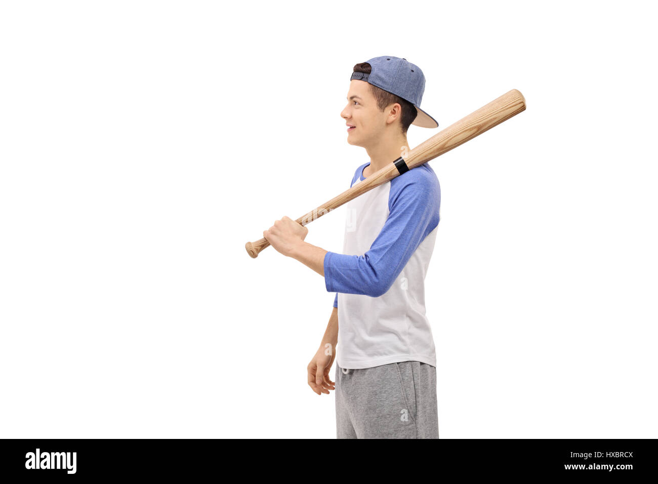 Colpo di profilo di un adolescente con una mazza da baseball e un cappuccio isolato su sfondo bianco Foto Stock