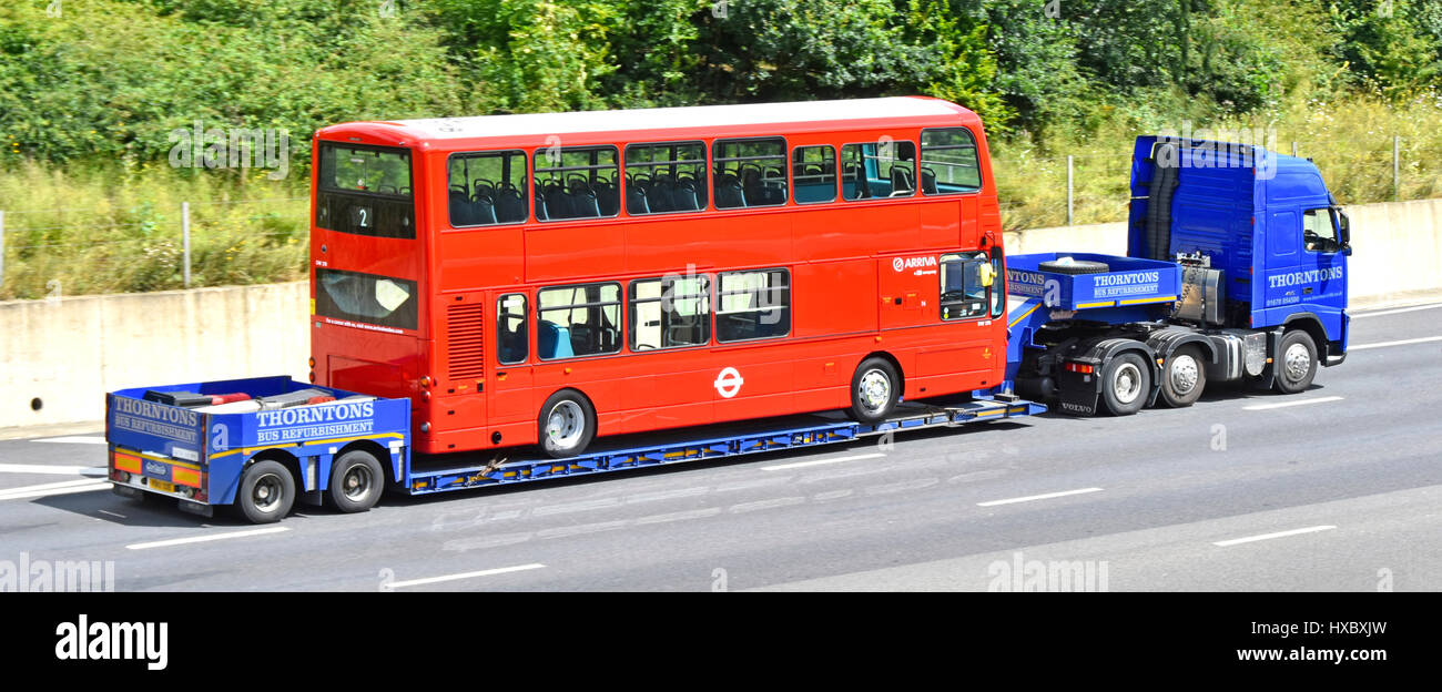 Arriva il London bus rosso a due piani di trasporto su un caricatore basso transporter viaggiando lentamente il trasporto lungo M25 Autostrada in Inghilterra Essex REGNO UNITO Foto Stock