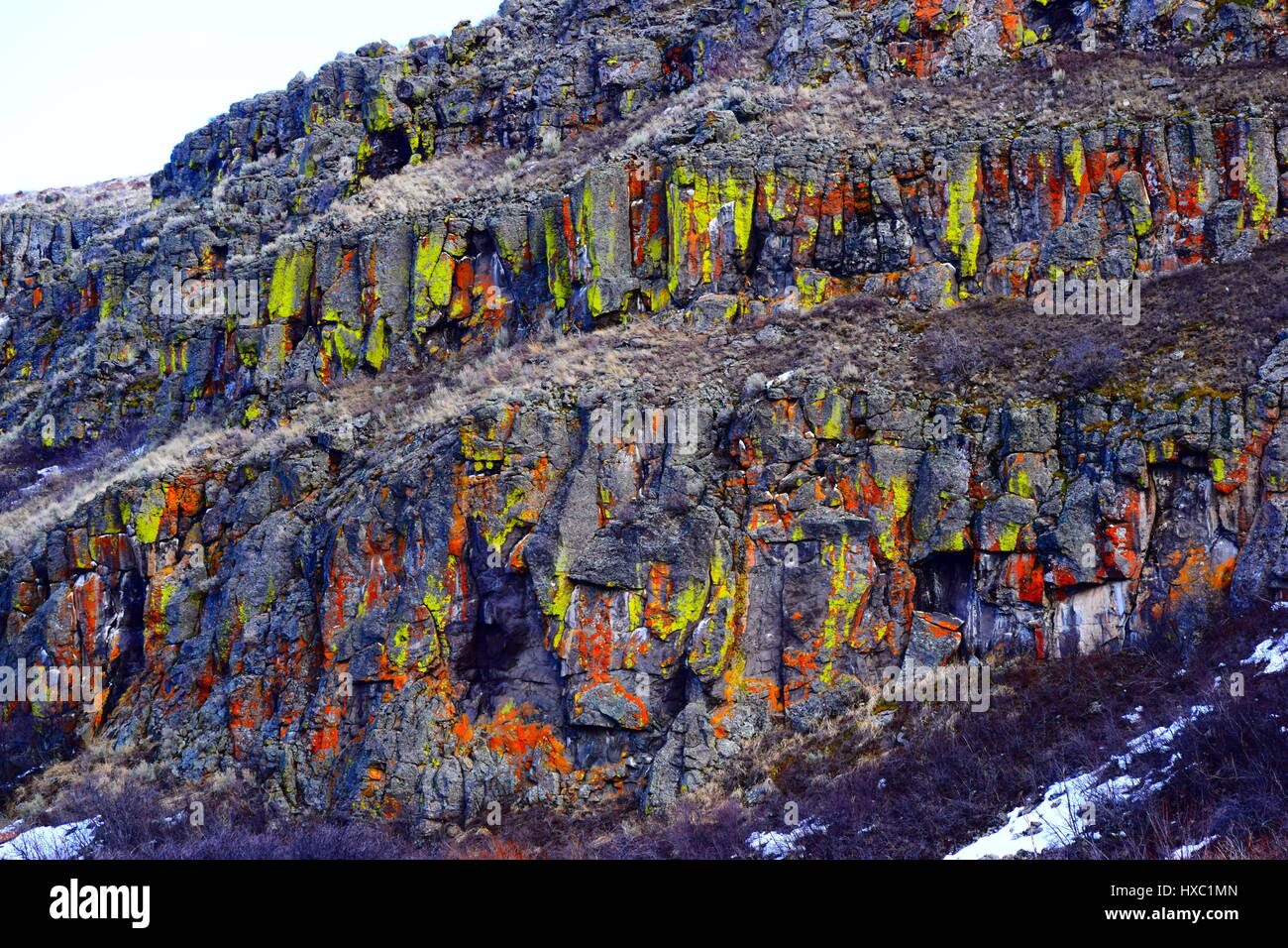 Medicina Lodge rocce con licheni crescono in verde, giallo, rosso e arancione su di essi. Lava pareti di roccia Foto Stock