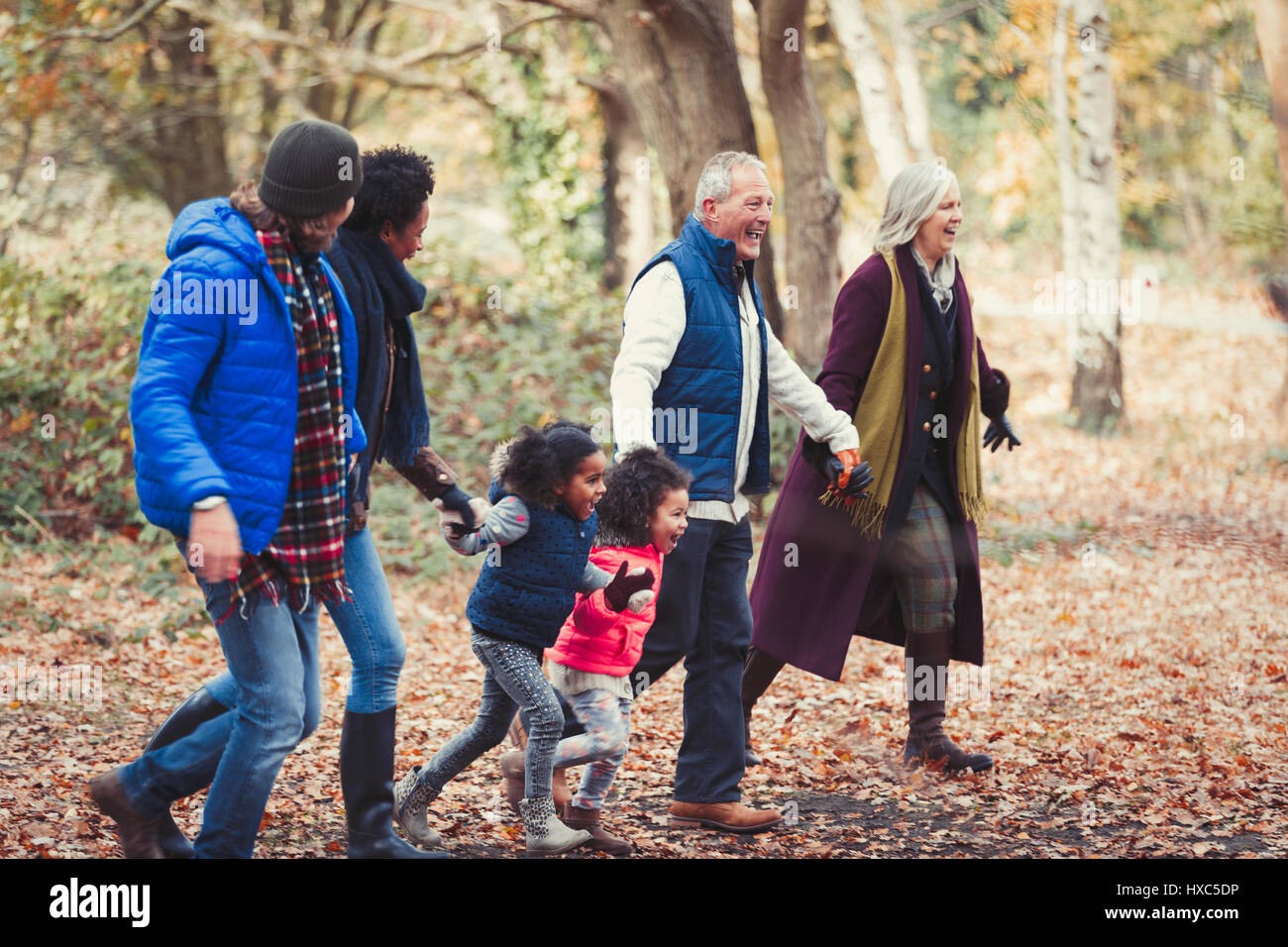 Multi-generazione famiglia holding hands passeggiate nel parco di autunno Foto Stock