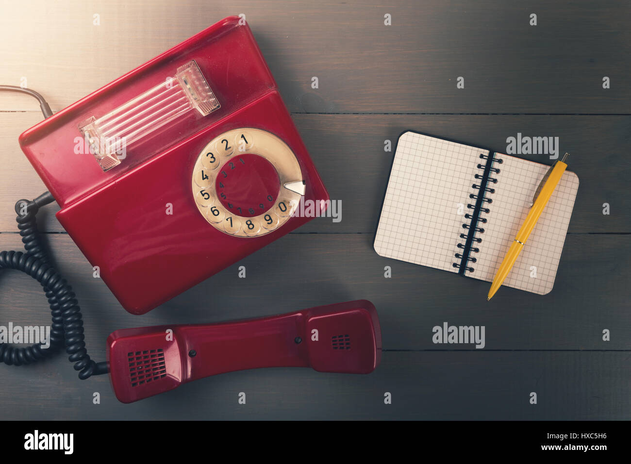 Vecchio telefono retrò con contatto portatile su un tavolo di legno. vista superiore Foto Stock